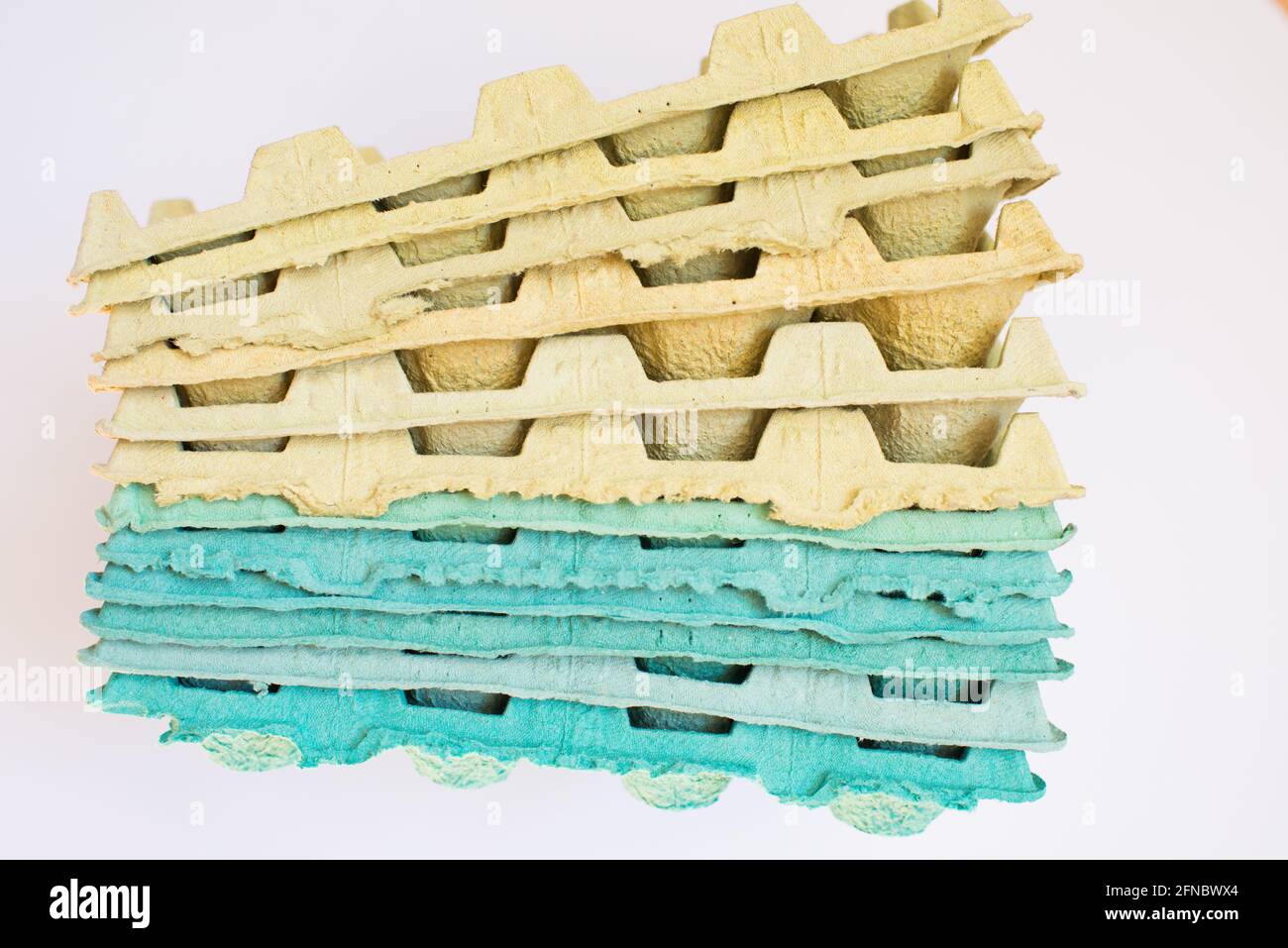 Texture. Pila di vassoi di cartone multicolore imballo per uova. Sfondo bianco Foto Stock