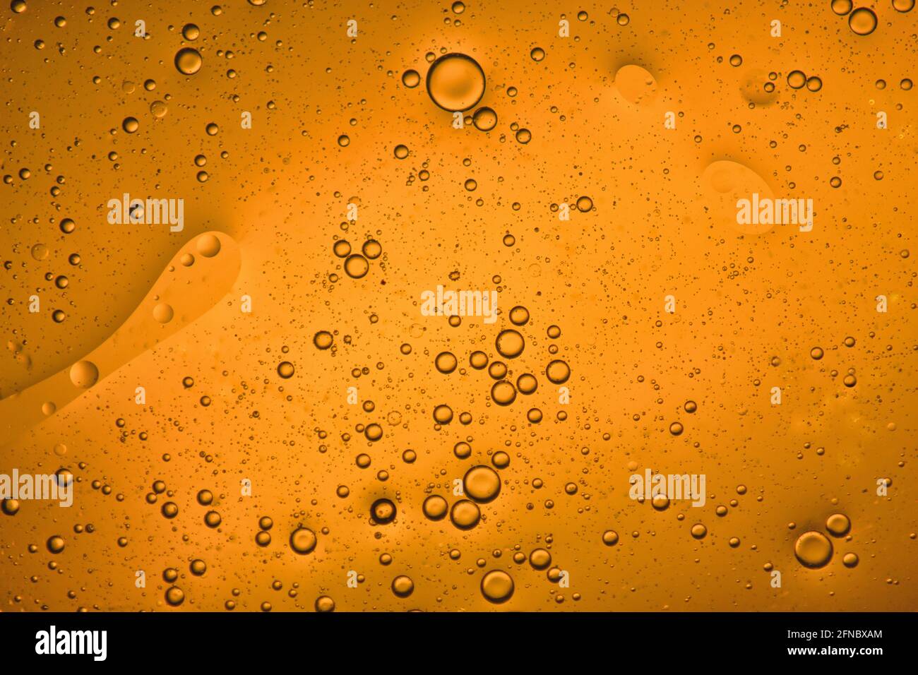 vista ravvicinata di uno sfondo liquido arancione di bolle in movimento Foto Stock