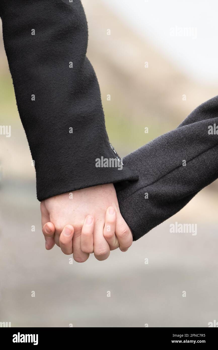 Giovane donna e uomo tengono le mani. Hanno amore. Foto Stock