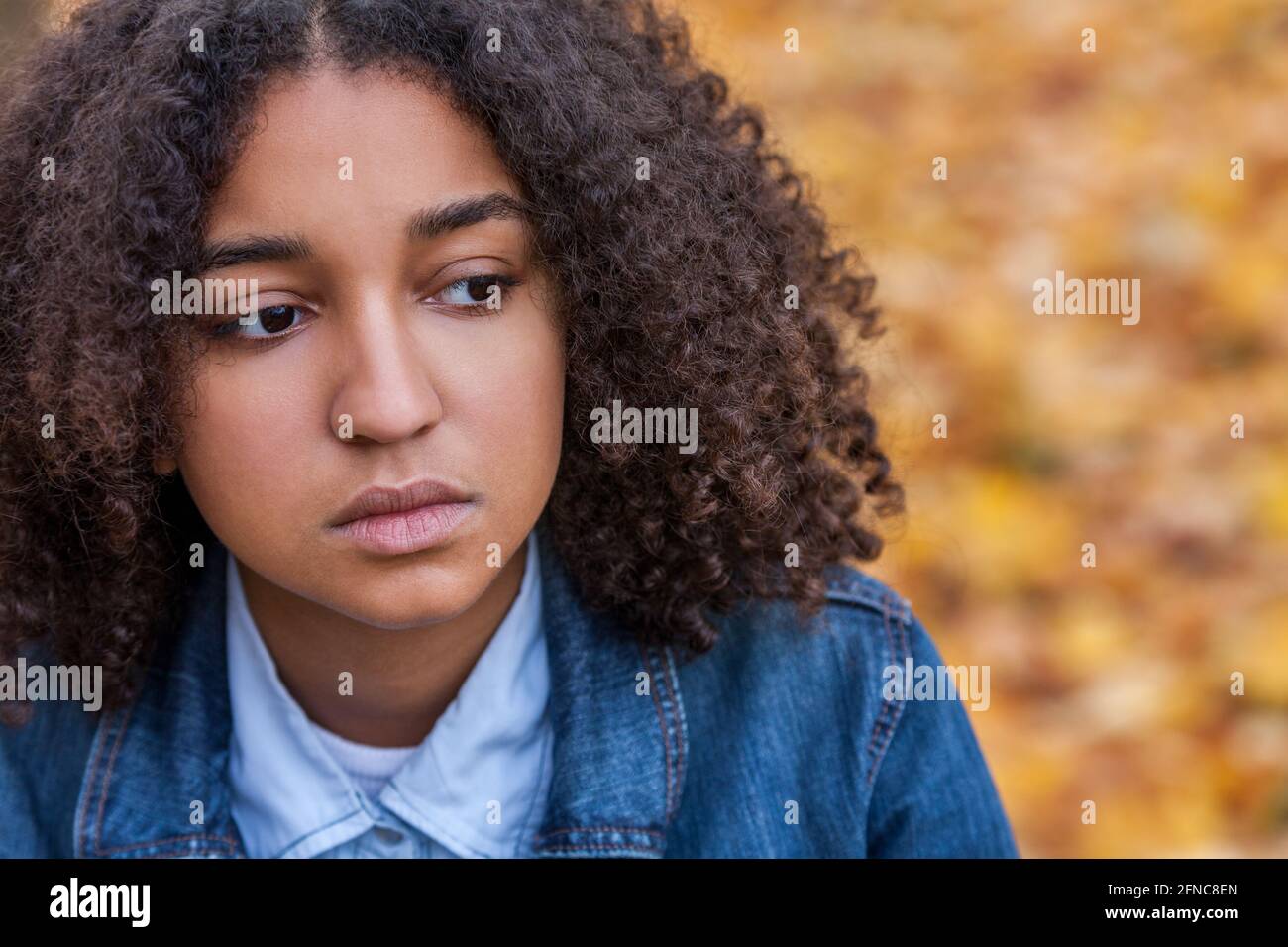 Bella razza mista Africana americana ragazza adolescente femmina giovane donna fuori cercando triste depresso o pensieroso, concetto di salute mentale Foto Stock