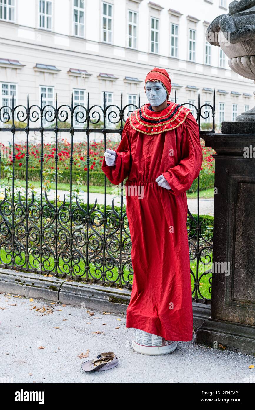 Un intrattenitore di strada vestito in un costume rosso a Salisburgo, Austria Foto Stock