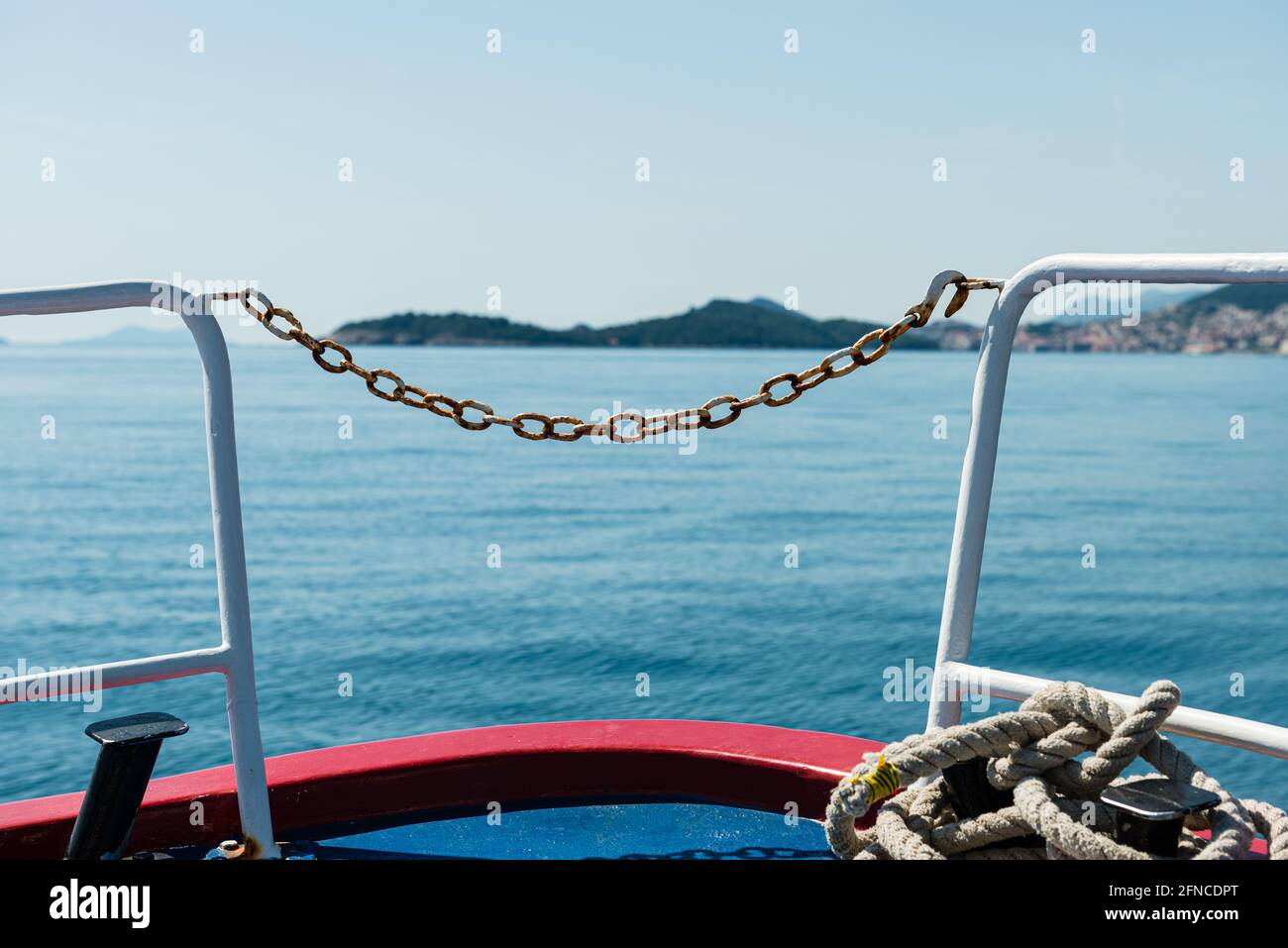 Catena arrugginita su una barca in mare che guarda verso Dubrovnik in Croazia Foto Stock
