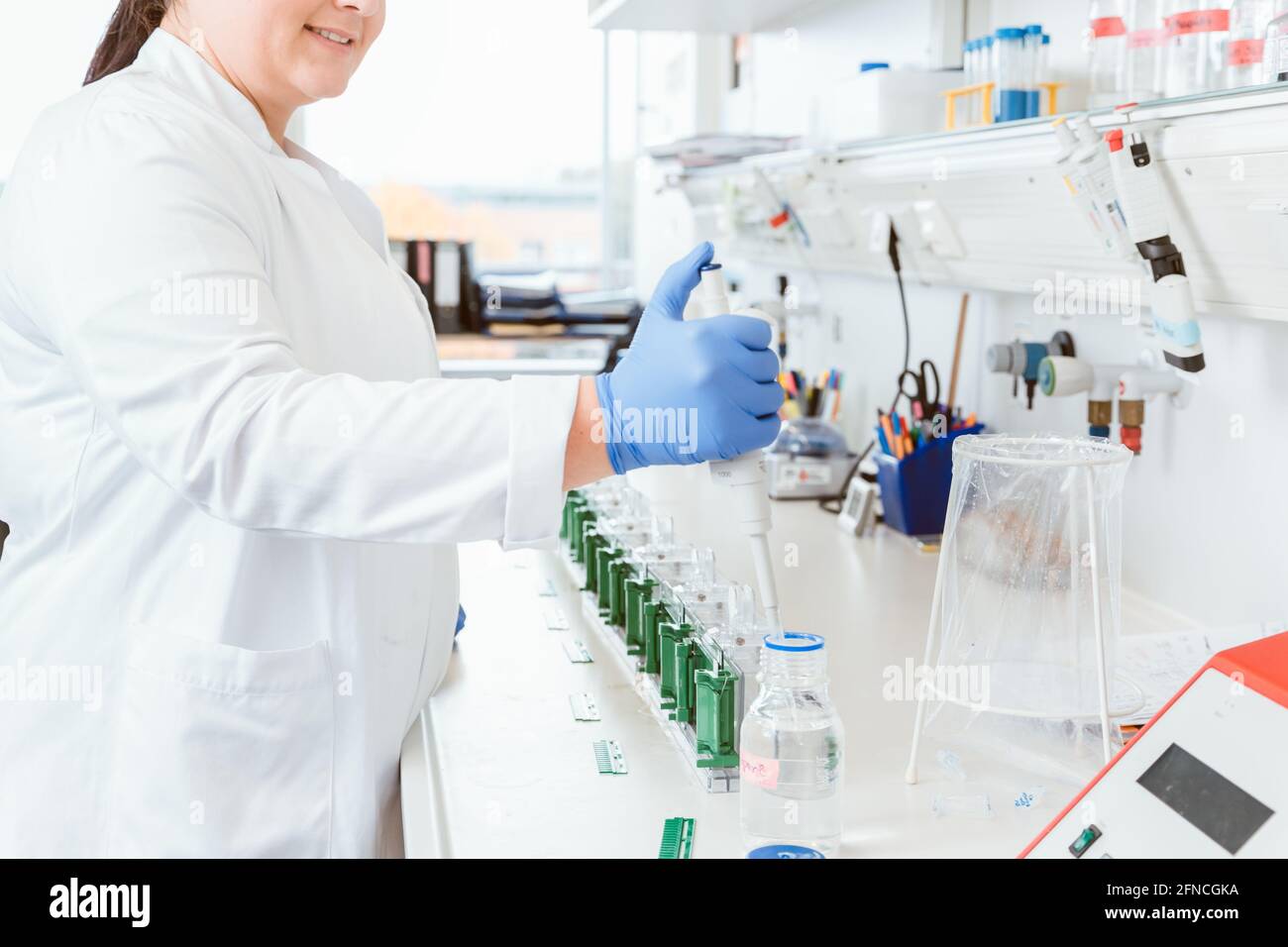 Donna medico che usa il contagocce in laboratorio Foto Stock