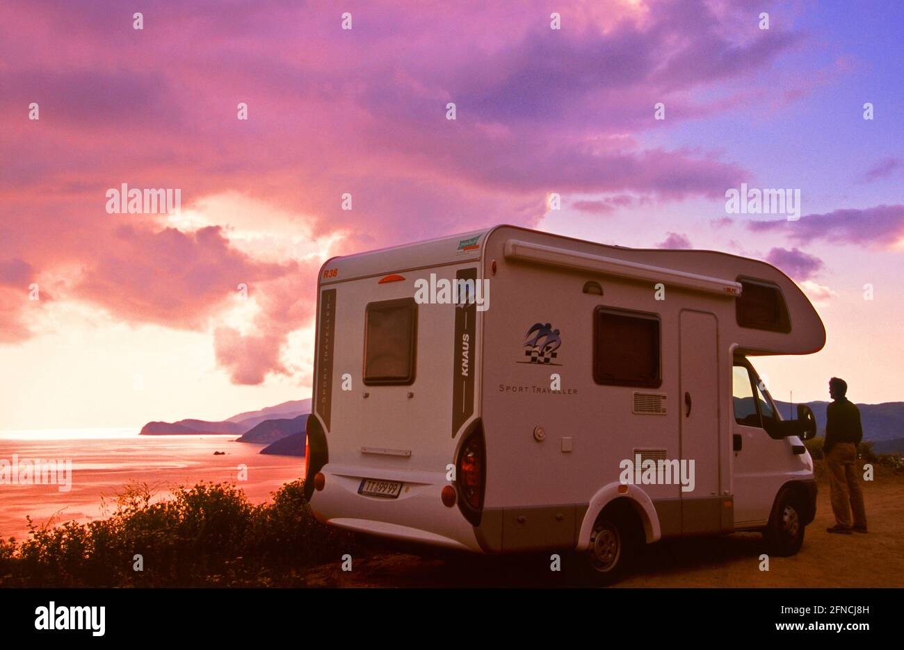 Uomo al suo Camper con vista al tramonto sull'isola d'Elba * Reisemobil an stimmungsvoller Aussicht auf die Südküste der Insel Elba . Foto Stock