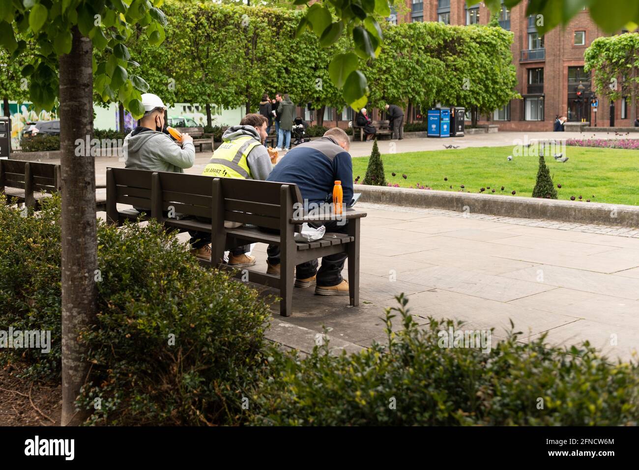 Lavoratori che hanno fatto una pausa seduti in panchina a Londra vicino St pauls Park Foto Stock