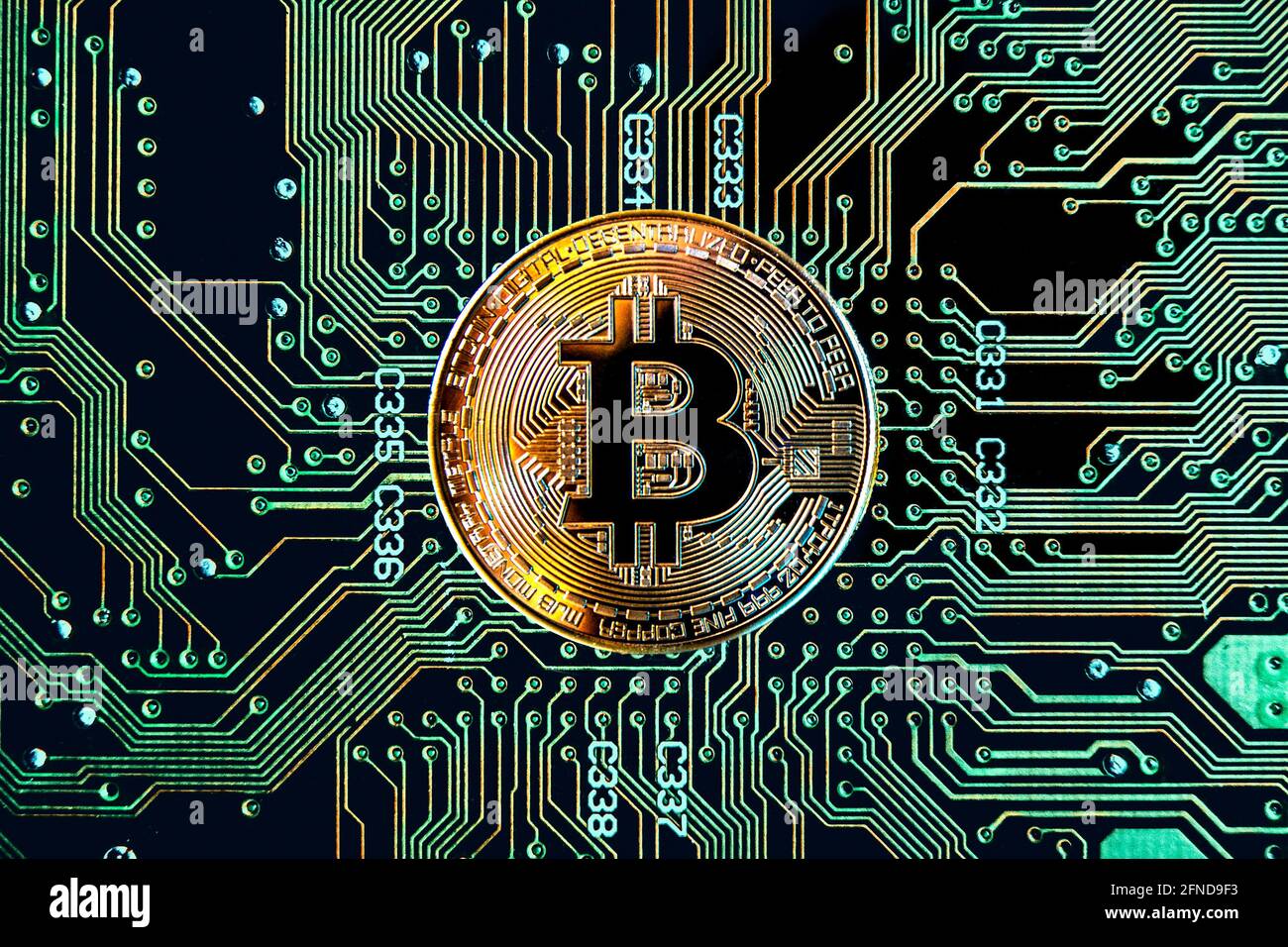 Gettone di criptovaluta Bitcoin contro lo sfondo della scheda a circuito stampato Foto Stock