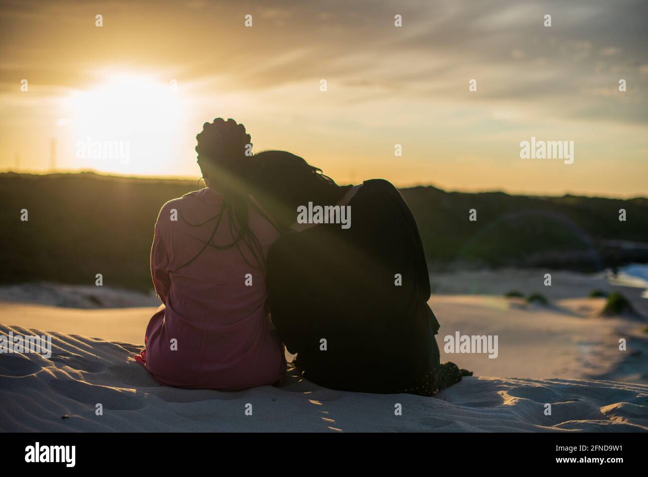 Donna appoggiata sull'amico mentre guardano l'alba Foto Stock