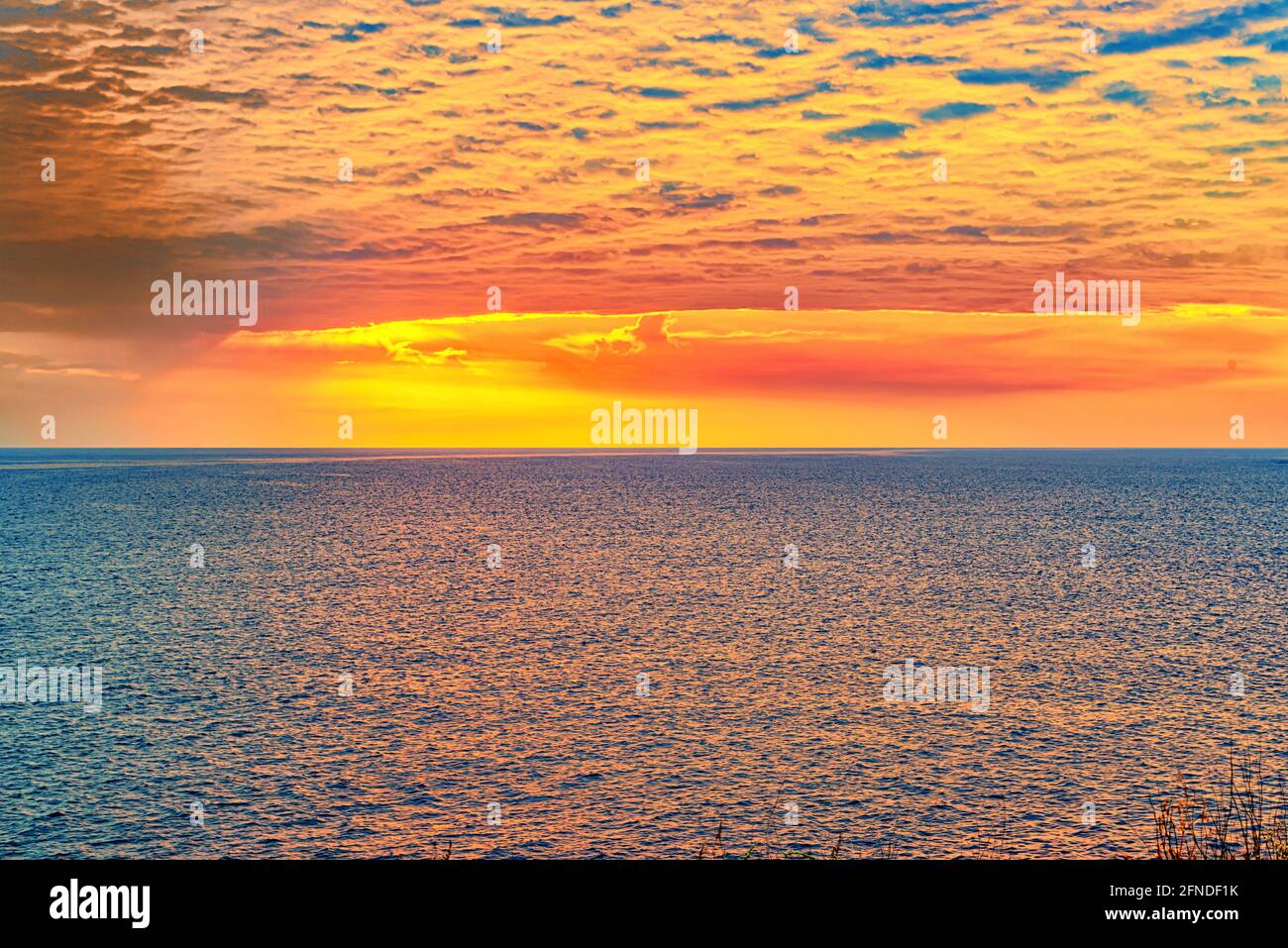 Il paesaggio di un luminoso e colorato tramonto sul mare Foto Stock Il paesaggio di un luminoso e colorato tramonto sul mare Foto Stock