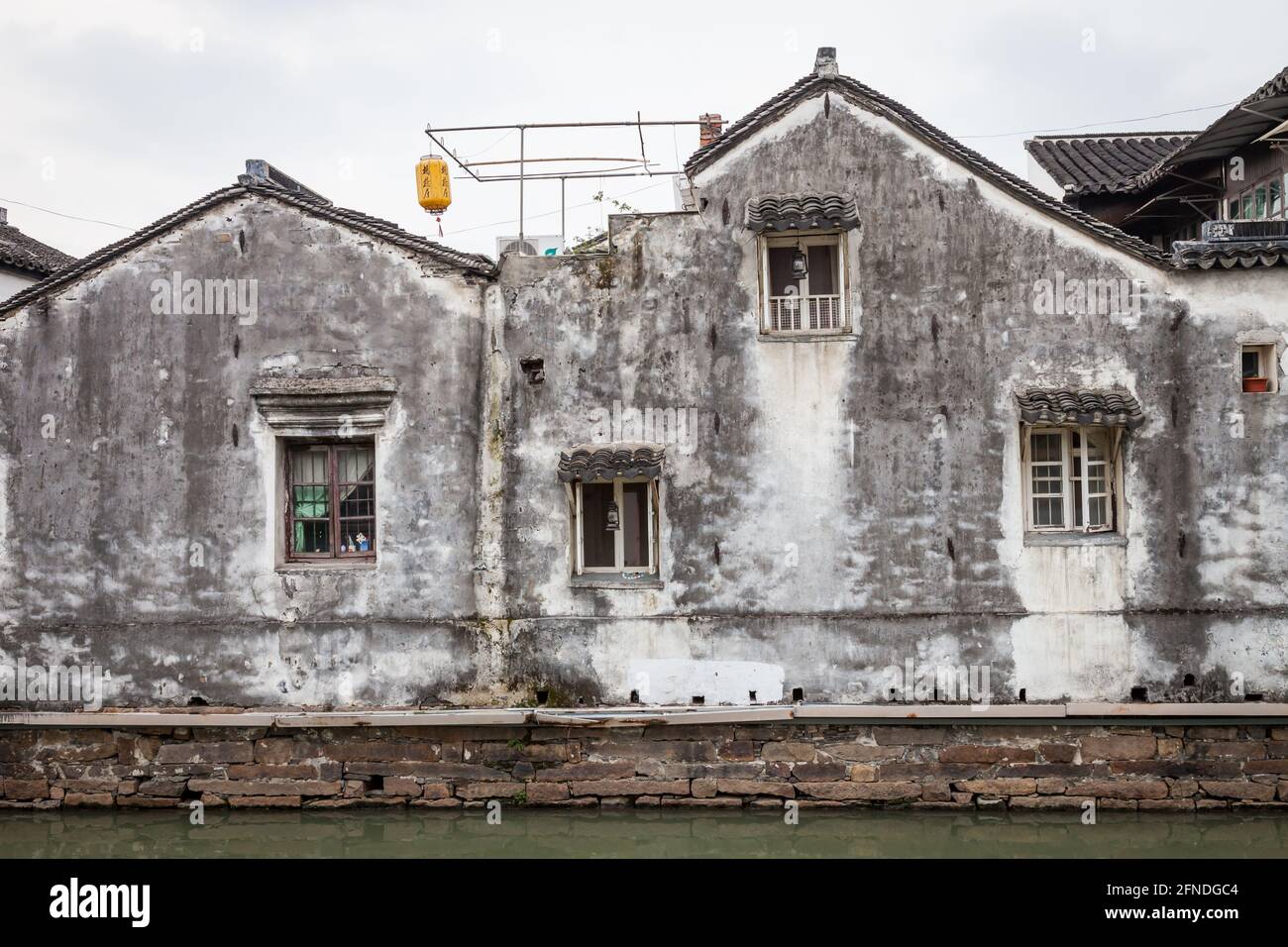 Vecchi edifici dilapidati lungo l'antico fossato della città vecchia di Suzhou. Foto Stock