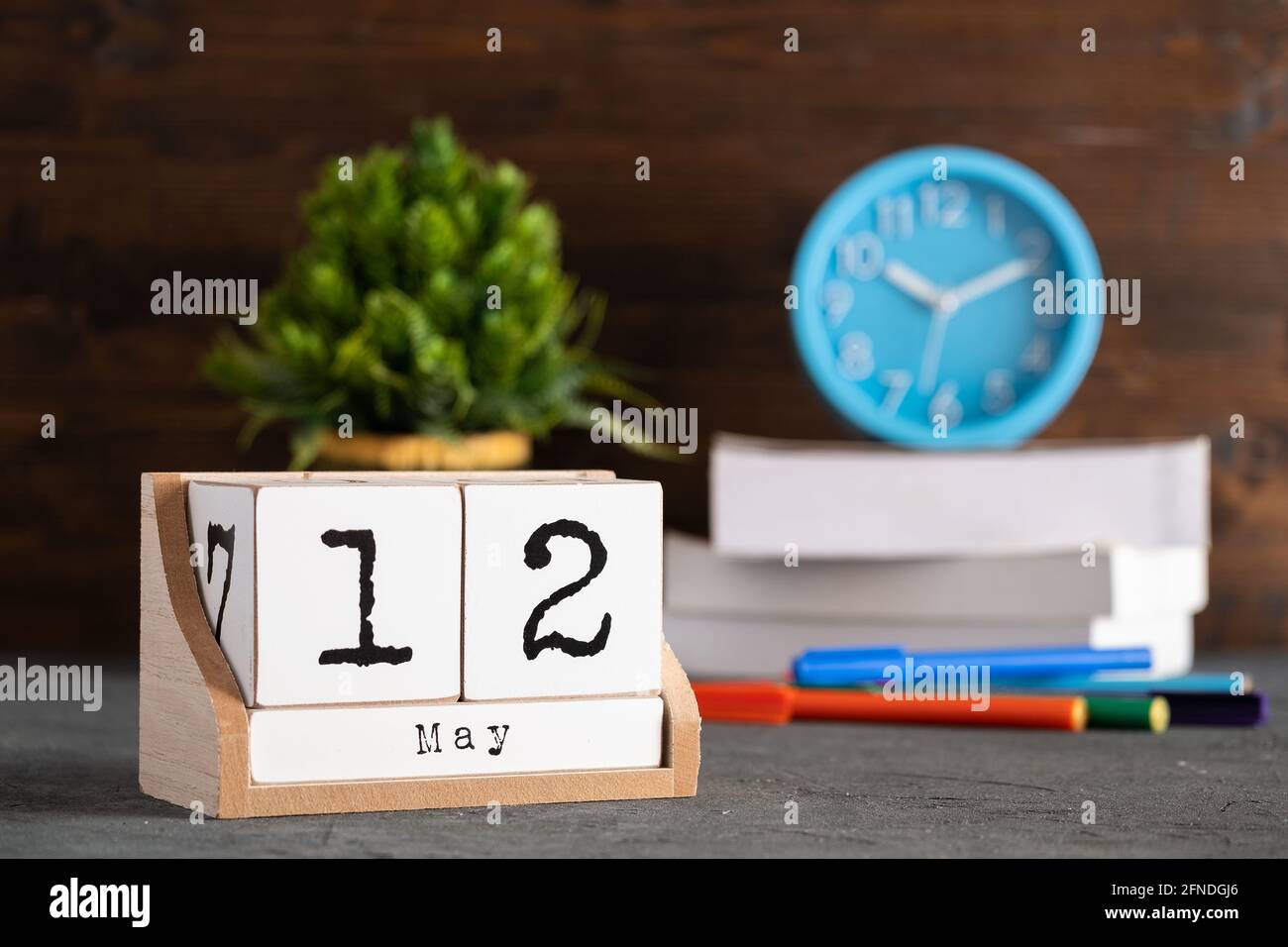 12 maggio. Maggio 12 calendario cubo di legno con oggetti sfocati sullo sfondo. Foto Stock