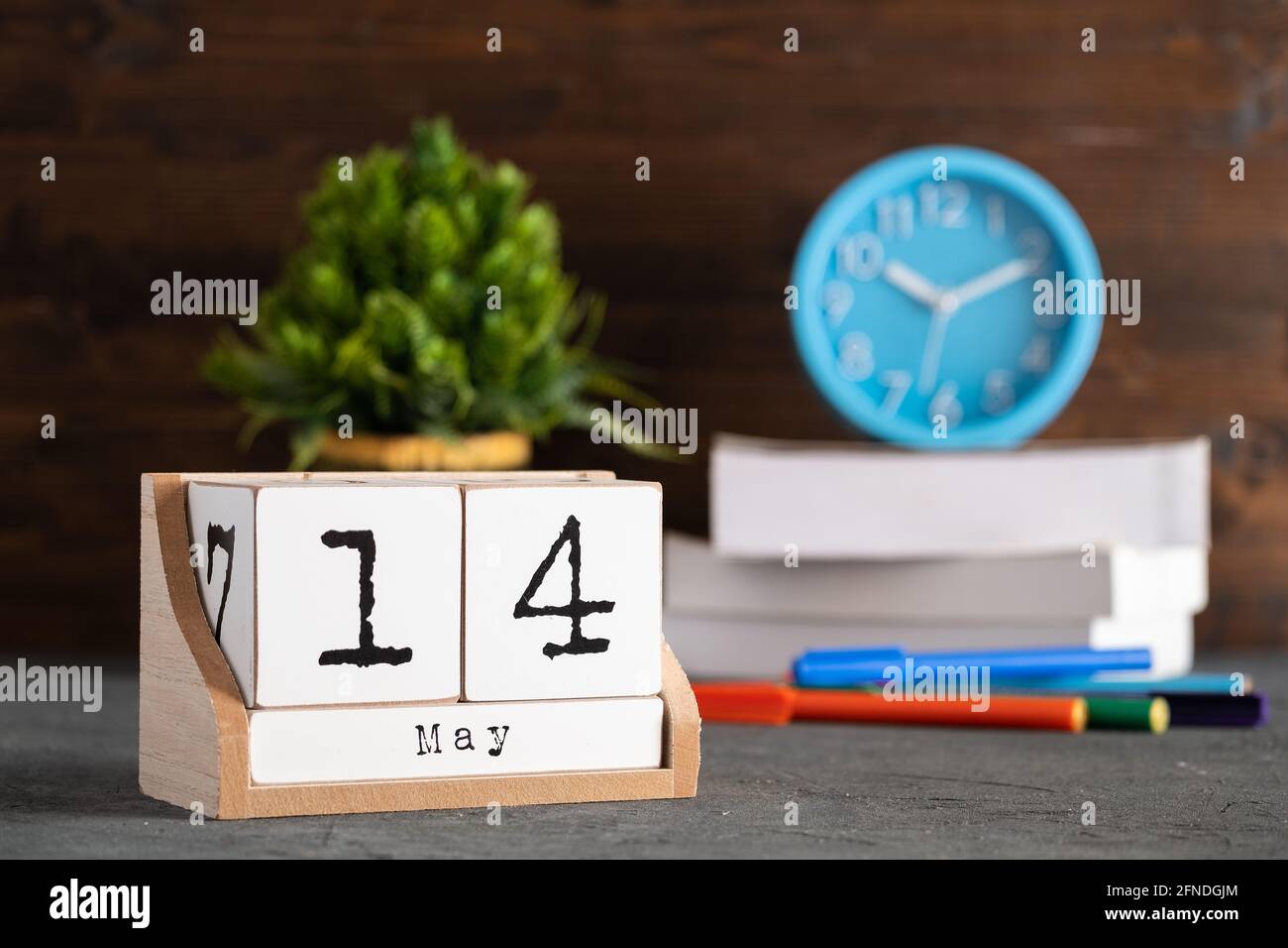 14 maggio. Maggio 14 calendario cubo di legno con oggetti sfocati sullo sfondo. Foto Stock