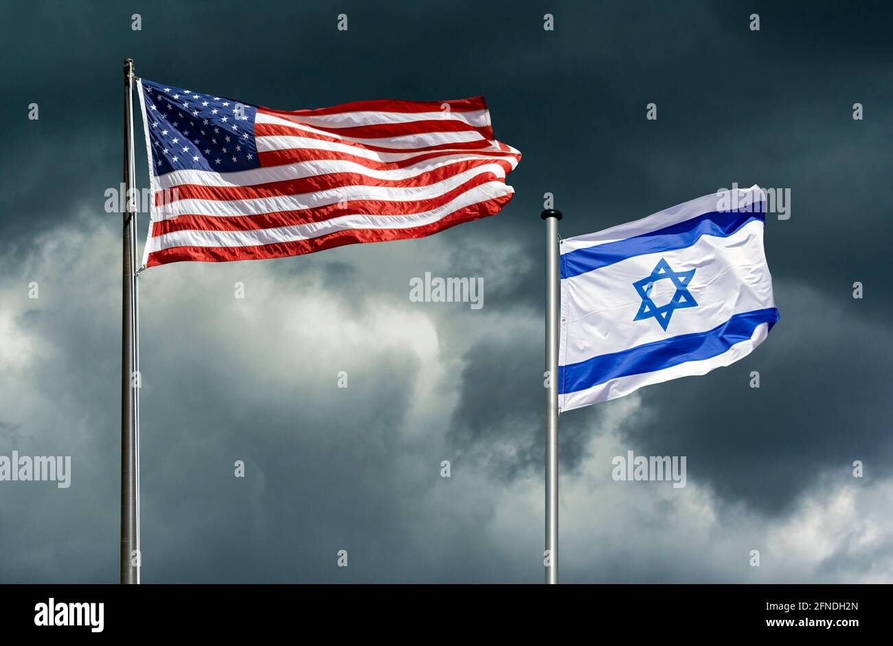 Bandiere di stato di USA e Israele che si flettono di fronte a un cielo oscuro e tempestoso, immagine simbolica per il partenariato tra Israele e gli Stati Uniti in tempi difficili Foto Stock