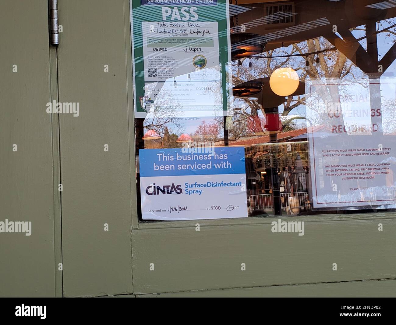 Primo piano delle norme di igiene e sicurezza COVID-19 pubblicate su una porta riflettente in vetro del Tutu's Food and drink a Lafayette, California, 23 febbraio 2021. () Foto Stock