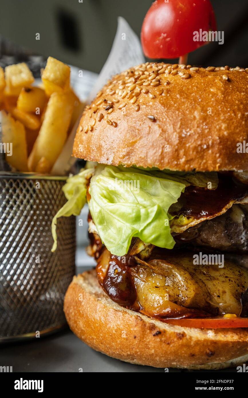 Primo piano su hamburger con patatine fritte sul tavolo al ristorante Foto Stock