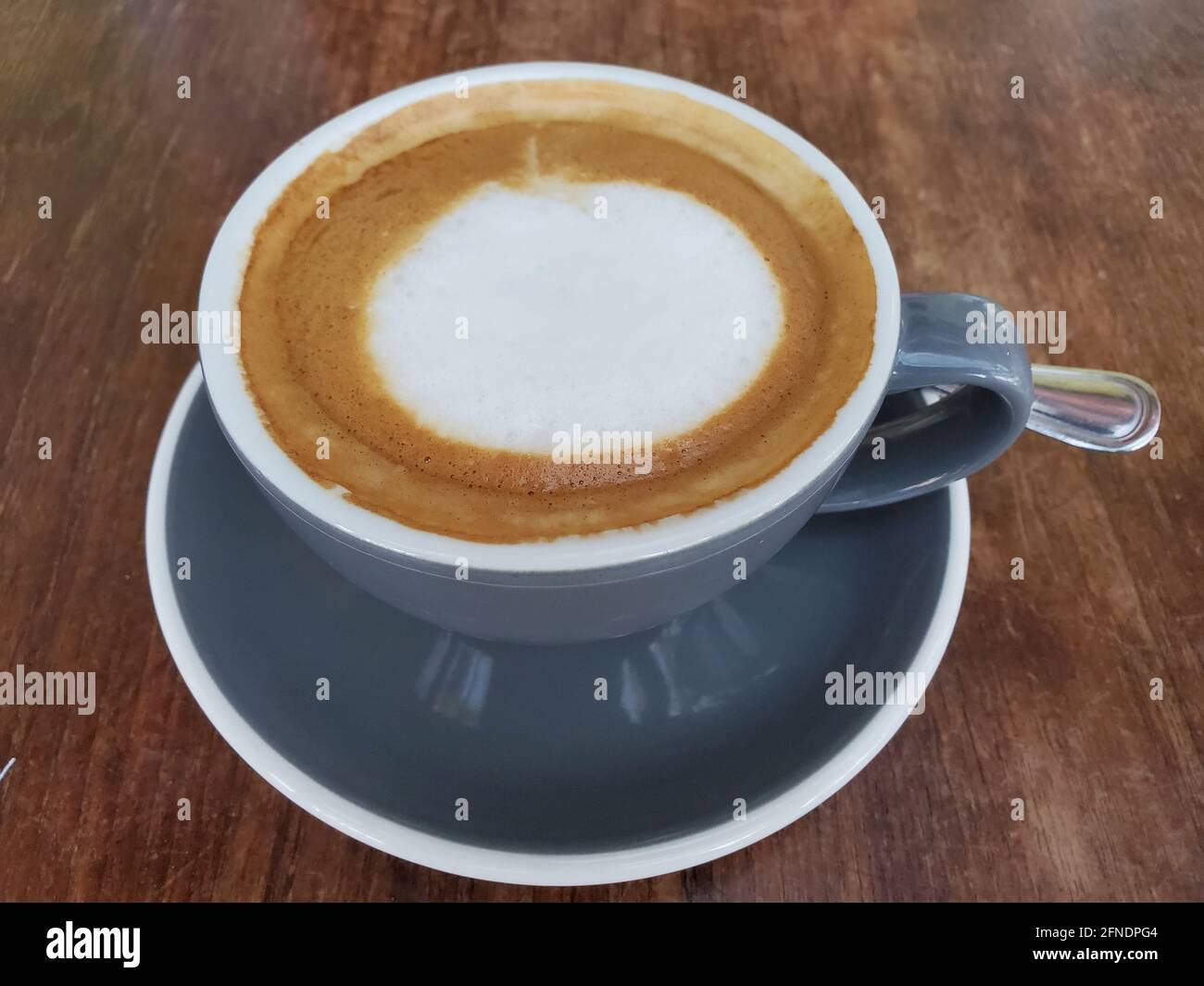 Primo piano di un latte di avena servito in una tazza su un piattino con un cucchiaio accanto a esso a Lafayette, California, 23 febbraio 2021. () Foto Stock