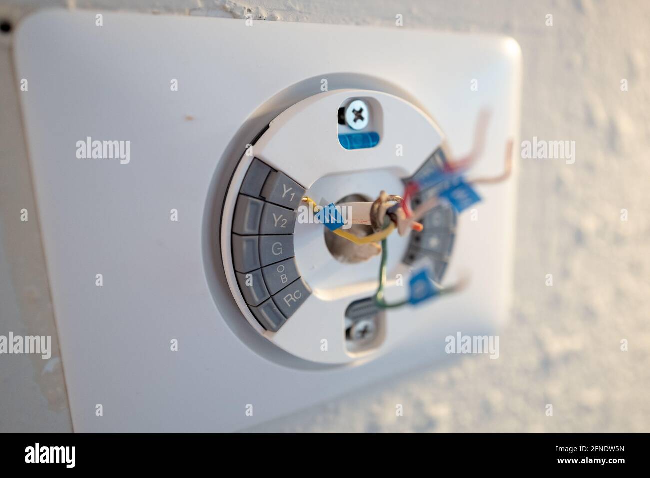 Fissaggio della piastra anteriore durante l'installazione di Google Nest Learning termostato durante un progetto di ristrutturazione intelligente della casa a Lafayette, California, 17 gennaio 2021. () Foto Stock