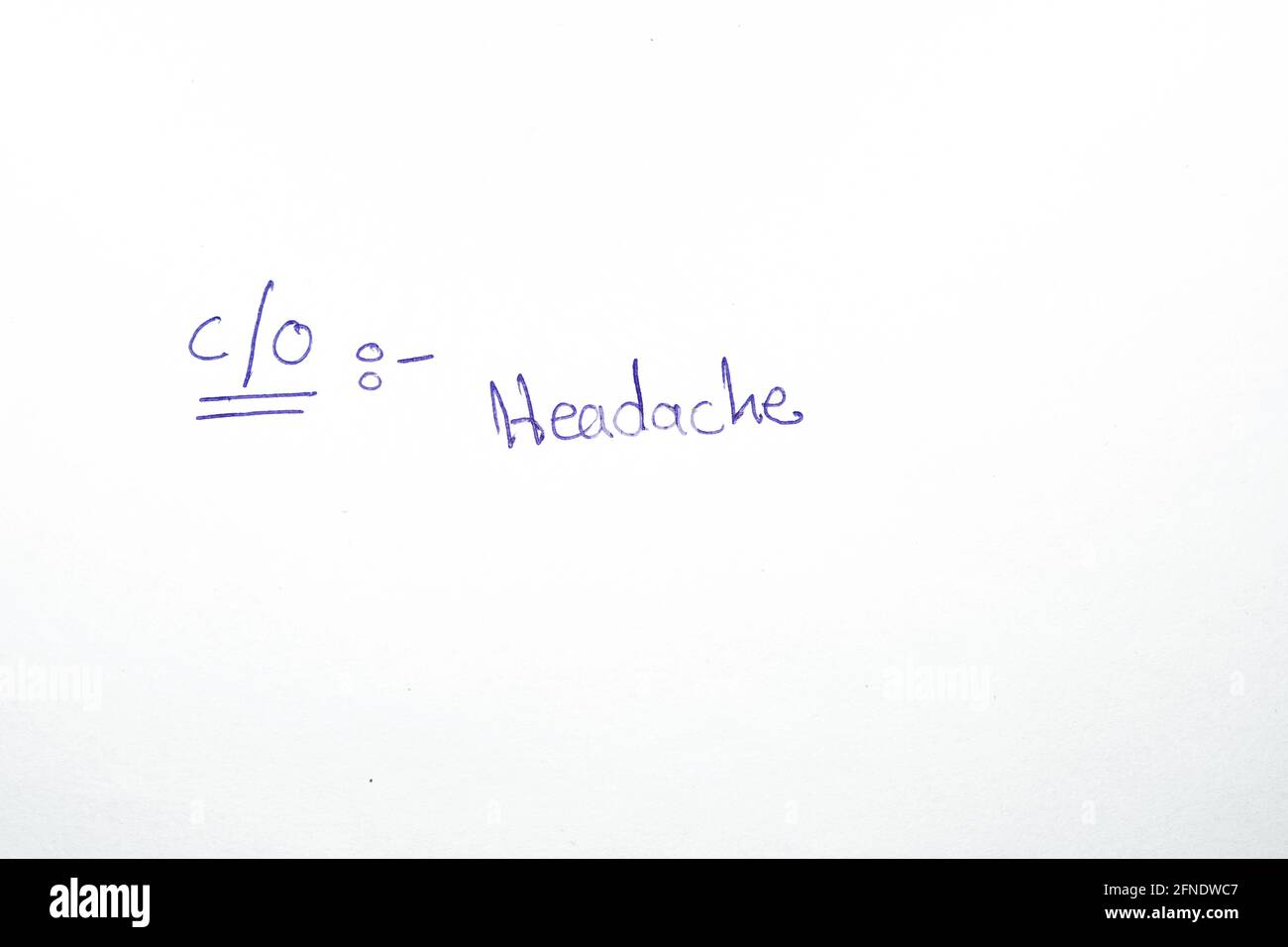 La parola mal di testa che è scritto a mano da un medico su un rapporto ospedaliero, mal di testa è uno dei sintomi comuni di molte malattie, tra cui il coron Foto Stock