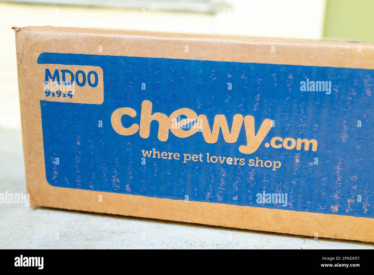 Primo piano angolato di una scatola da un rivenditore online di prodotti per animali domestici, che riposa su un banco di colore chiaro, 17 febbraio 2021. () Foto Stock