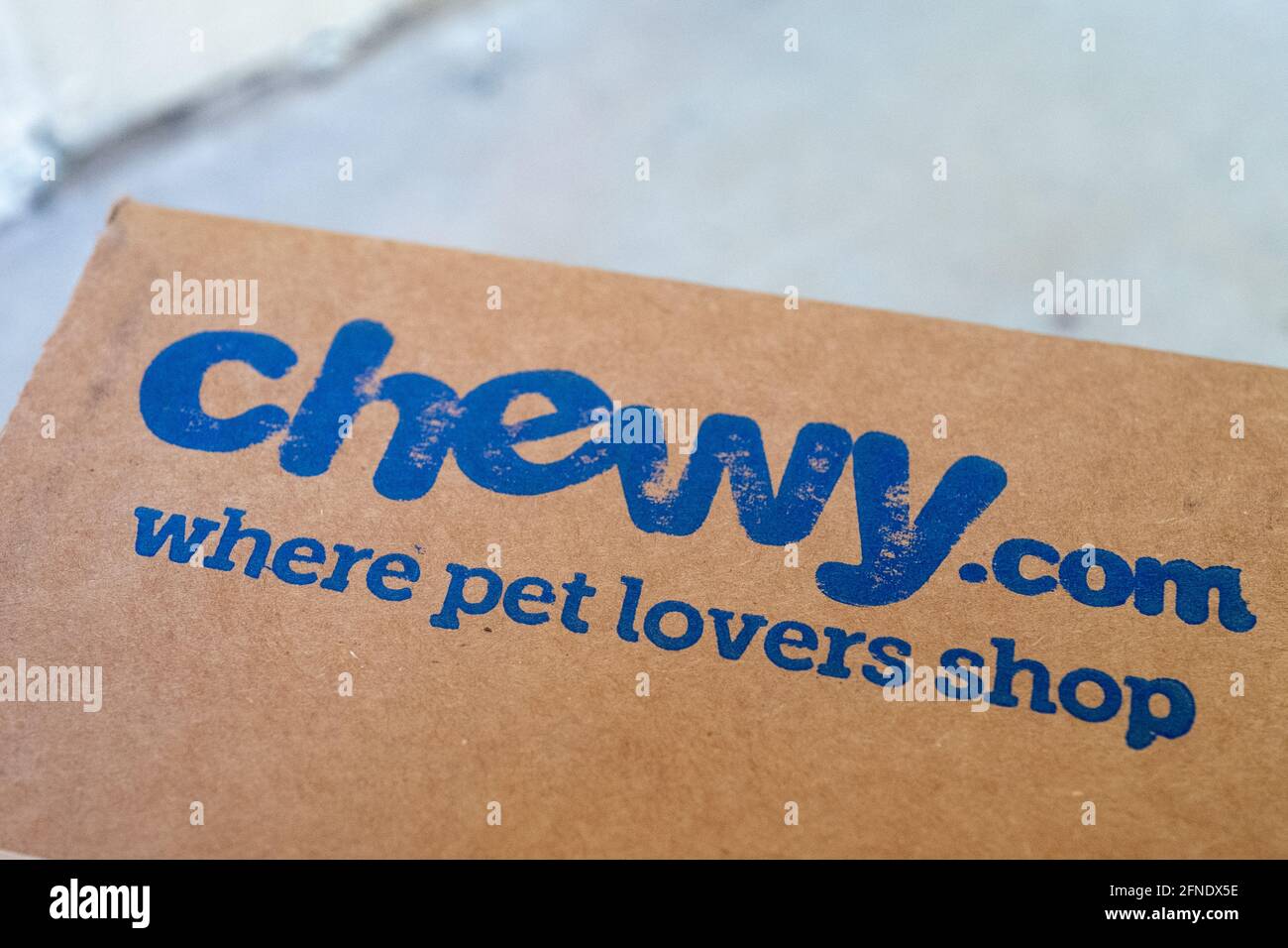 Primo piano di un logo 'Chewy.com Where PET Lovers Shop' su una scatola del rivenditore online di prodotti per animali domestici Chewy, 17 febbraio 2021. () Foto Stock