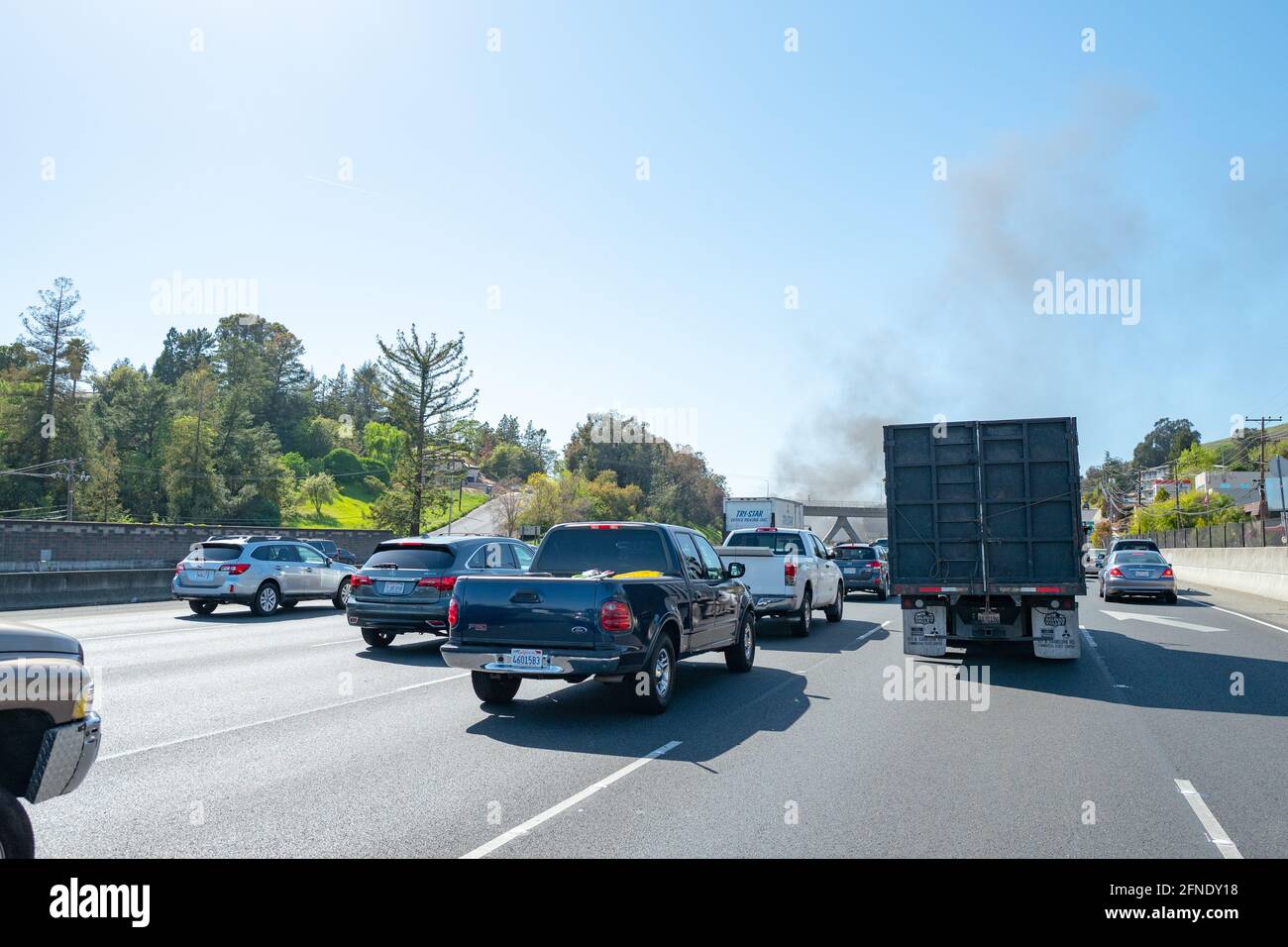 Il fumo proveniente da un incendio è visibile sopra il traffico sull'autostrada 24 a Lafayette, California, aprile 2021. () Foto Stock