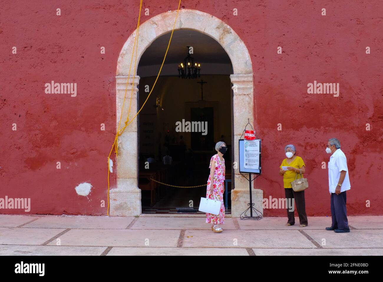 I churchgoers che indossano le maschere di fronte alla chiesa durante il Covid-19 Pandemic, Merida Messico Foto Stock