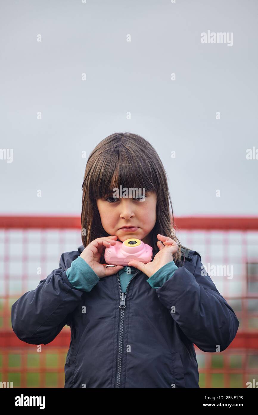 Ritratto di bambina caucasica di 5 anni con macchina fotografica giocattolo Foto Stock