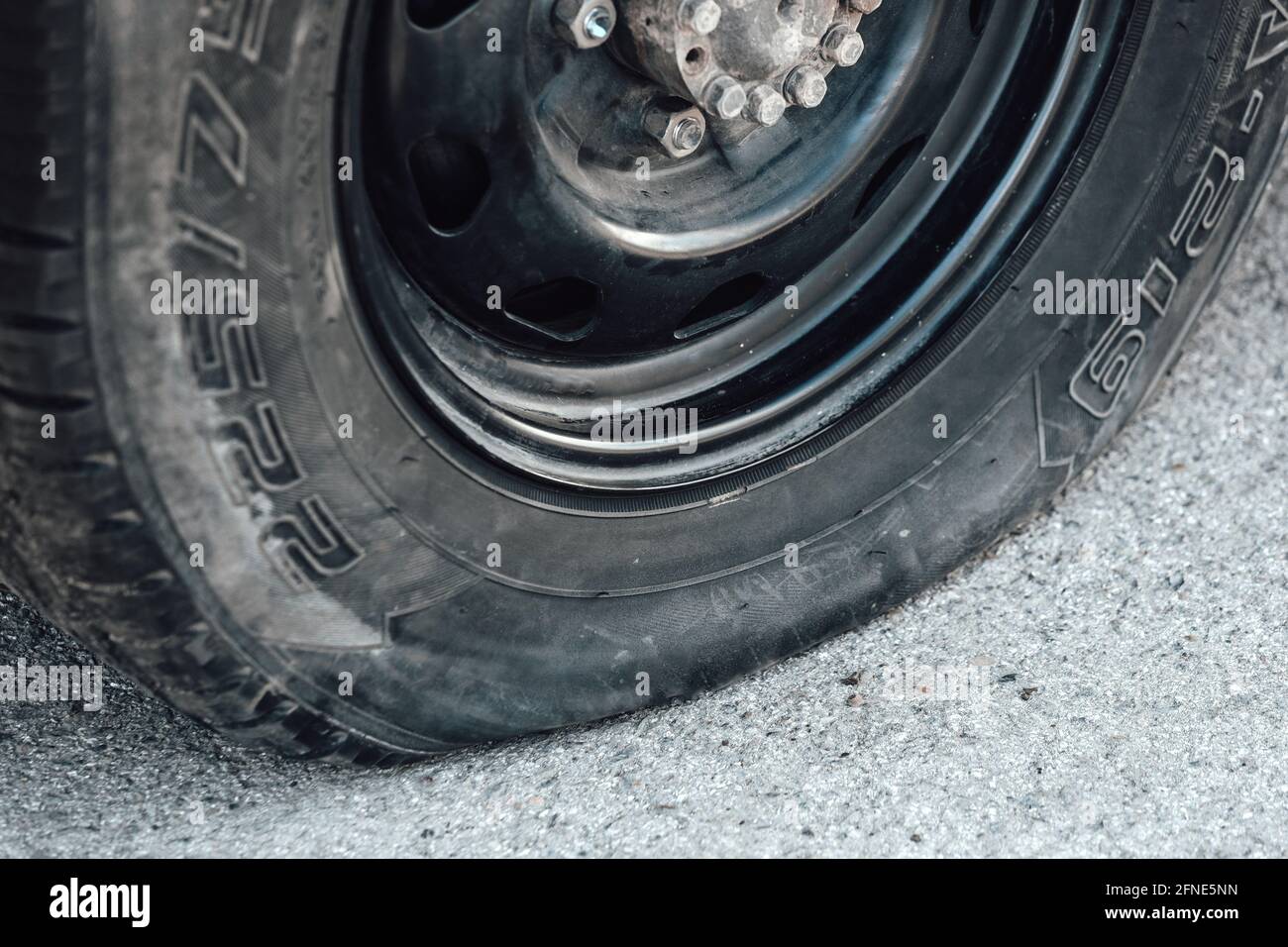primo piano pneumatico sgonfio. Un problema sulla strada. Una ruota forata sulla strada. Foto Stock