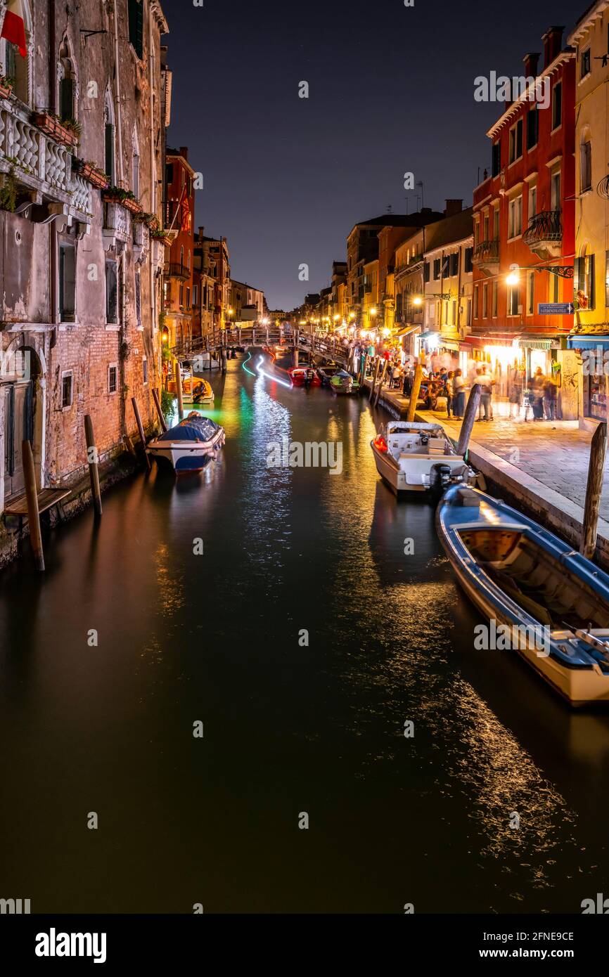 Atmosfera serale, lampioni, canale con barche ed edifici storici, tracce chiare, Venezia, Veneto, Italia Foto Stock