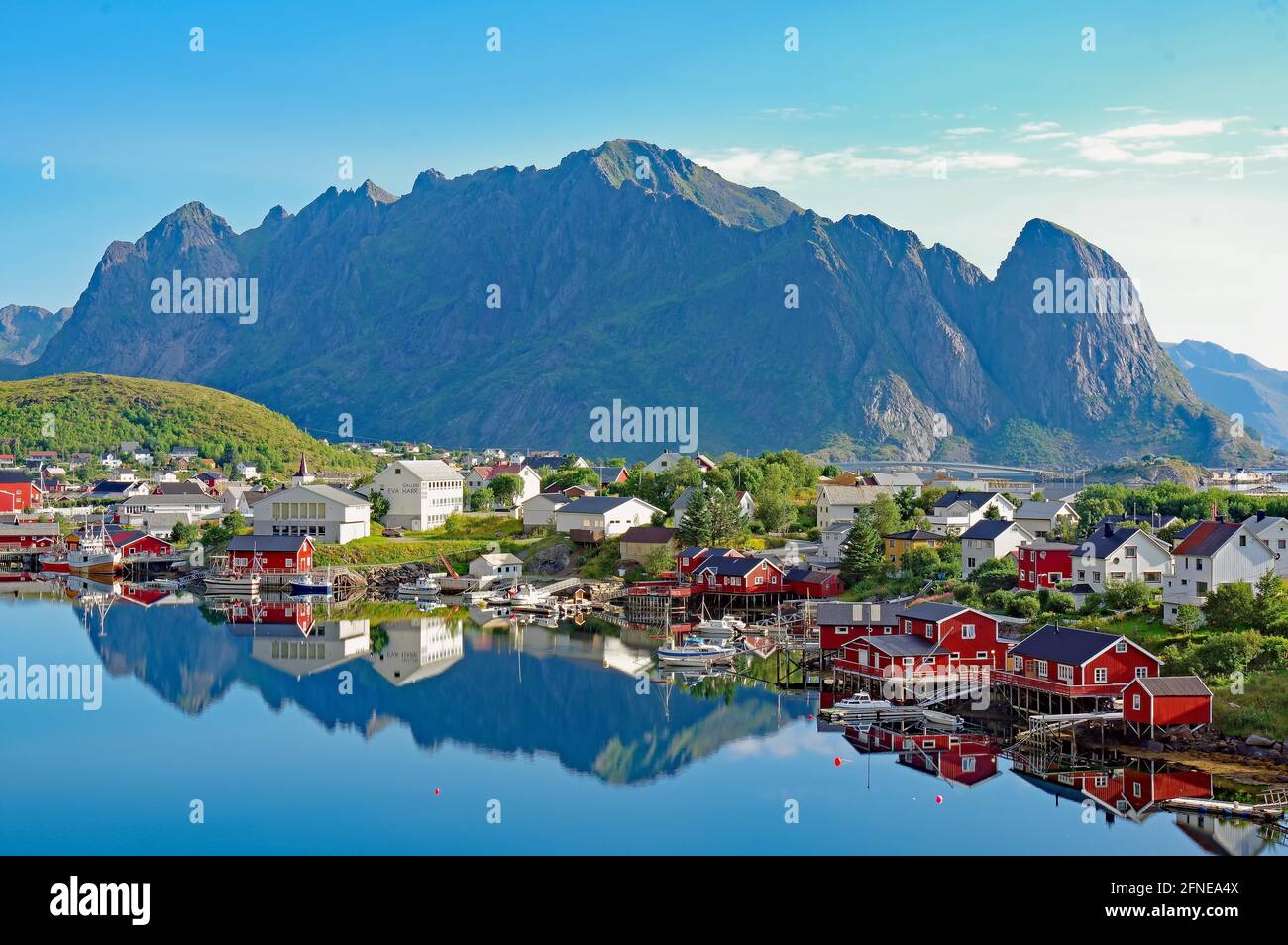 Village view, Reinefjord con montagne e case di legno rosso, Reine, Moskenesoey, Lofoten, Nordland, Norvegia Foto Stock