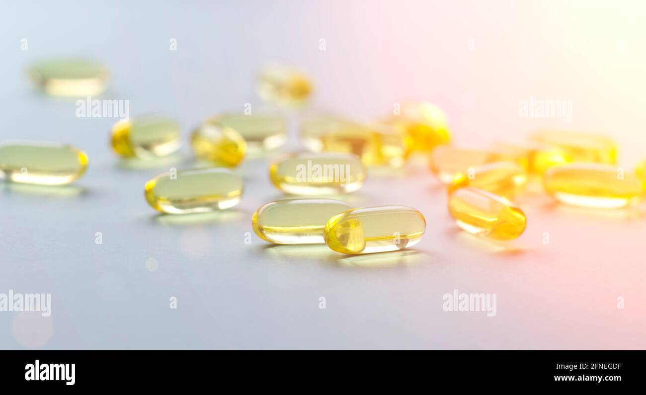 Olio di pesce Omega sfondo. Vitamine Omega in pillole gialle come fonte di  salute. Foto di alta qualità Foto stock - Alamy