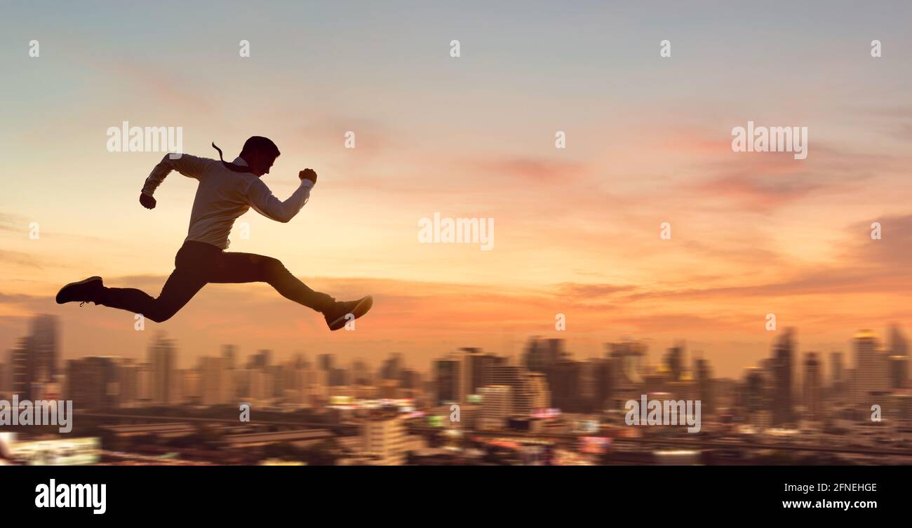 Giovane uomo d'affari che salta alto, lavoro, lavoro, o concetto riuscito di affari. Sfondo urbano. Foto Stock