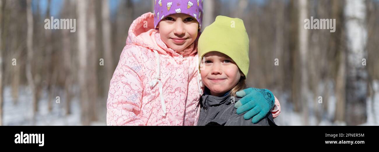 Mosca, Russia, marzo 2021 - felici bambini, una sorella di ragazza e un fratello di ragazzo, in abiti primaverili, abbracciando, ponendosi e guardando la macchina fotografica su un Foto Stock