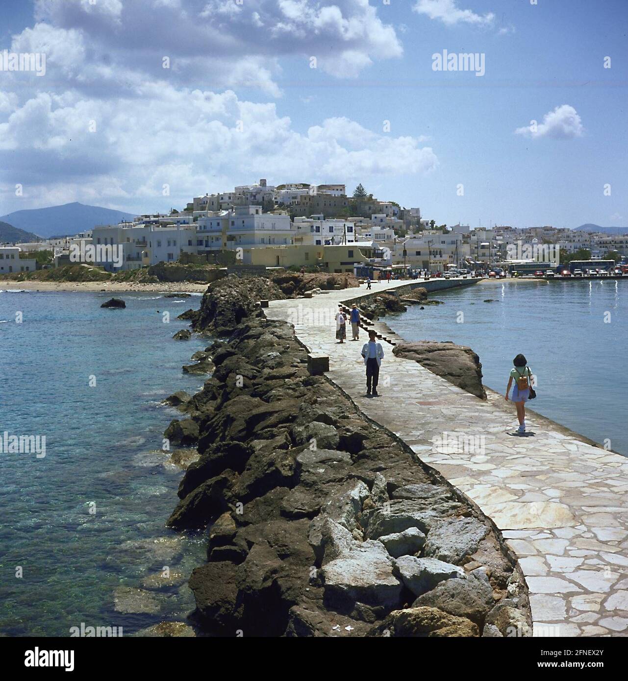 Una strada rialzata collega la città di Naxos con l'isolotto offshore di Palatia, dove sorge la porta del tempio (Portara) e il punto di riferimento della città. [traduzione automatizzata] Foto Stock