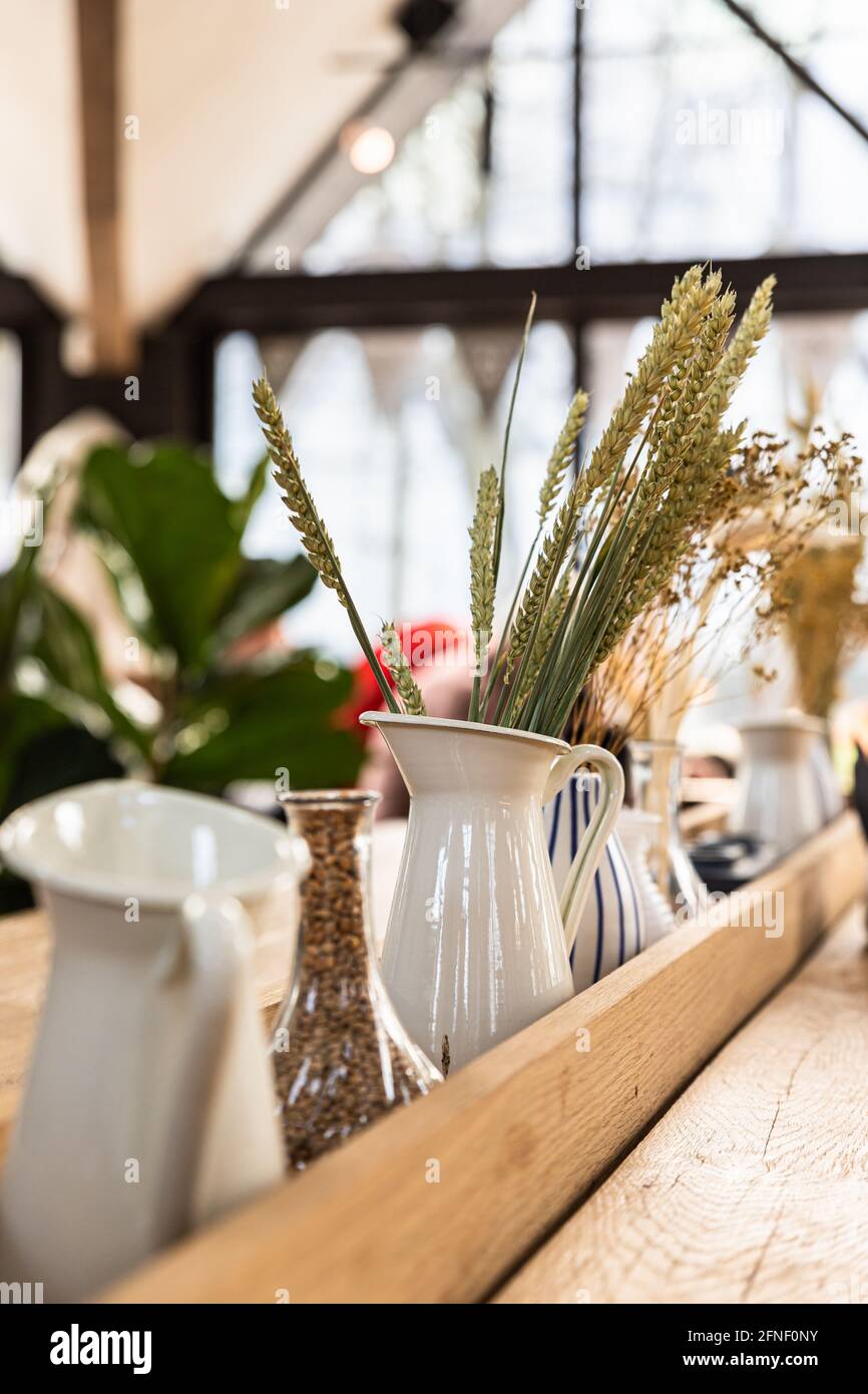 Dettagli dell'interno di un moderno caffè o di una caffetteria con orecchie di grano in vaso. Design moderno. Foto Stock