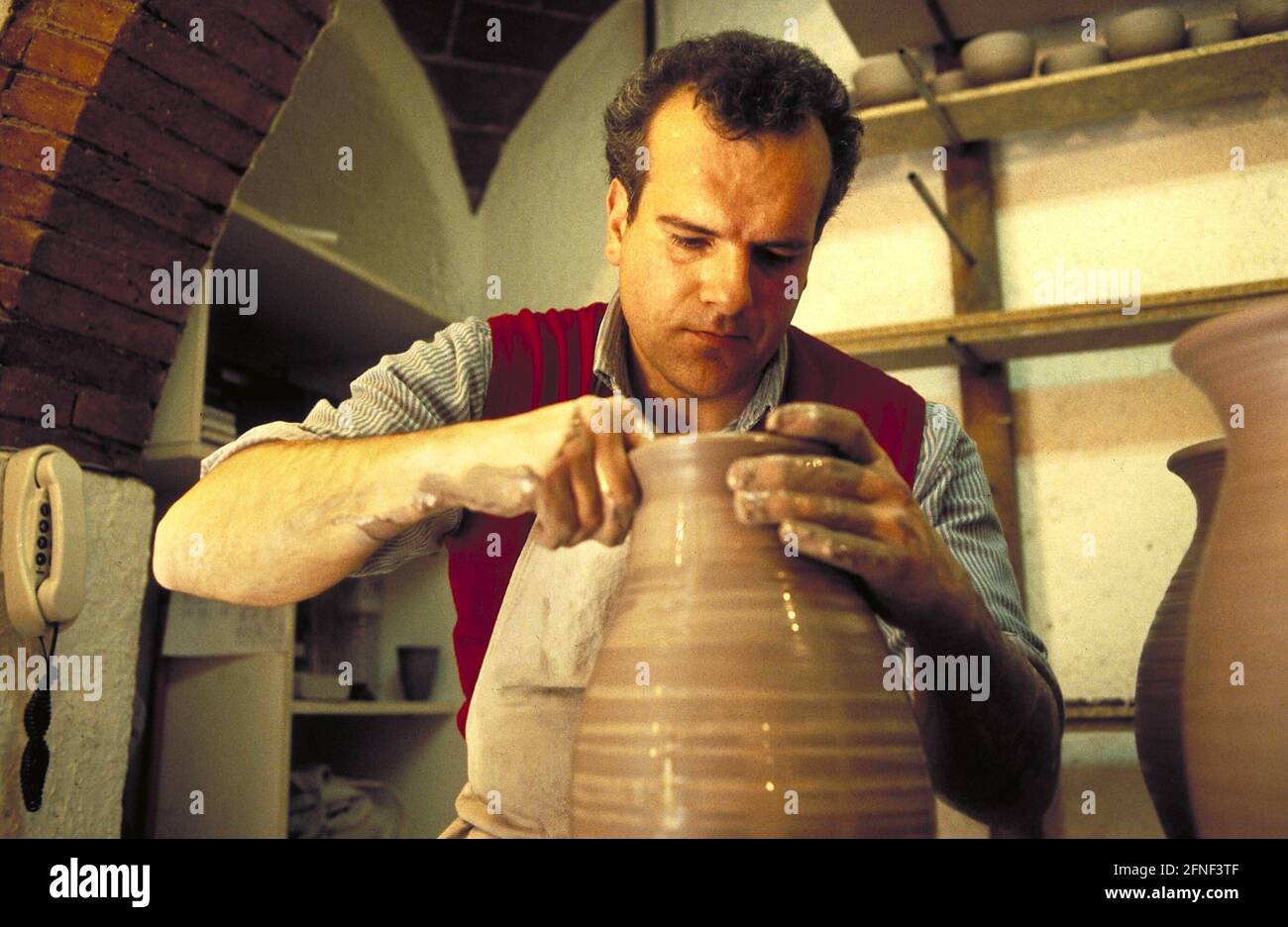 Un uomo sta vasellando una caraffa. [traduzione automatizzata] Foto Stock