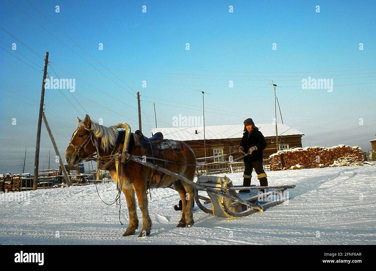 Uomo con slitta trainata da cavalli davanti alla sua casa in Siberian Yakutia. [traduzione automatizzata] Foto Stock