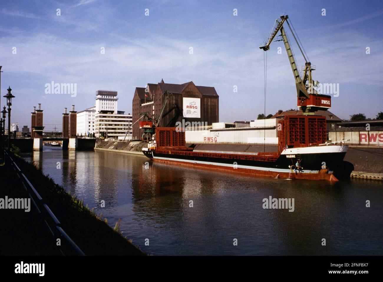 Vista di una parte del porto interno di Duisburg. Sul lato destro delle gru e del granaio della Rheinisch-Westfälische Speditions GmbH (RWSG) Duisburg. Oggi, l'edificio del magazzino ospita gli archivi di stato della Renania Settentrionale-Vestfalia. Il Swan Gate Bridge può essere visto sullo sfondo. L'area del porto interno è stata ricostruita e modernizzata come parte dell'esposizione internazionale degli edifici nel progetto "Working, Living and Living by the Water". Foto non datata. Circa 1995 perché l'esposizione dell'edificio si è svolta quest'anno. [traduzione automatizzata]" Foto Stock