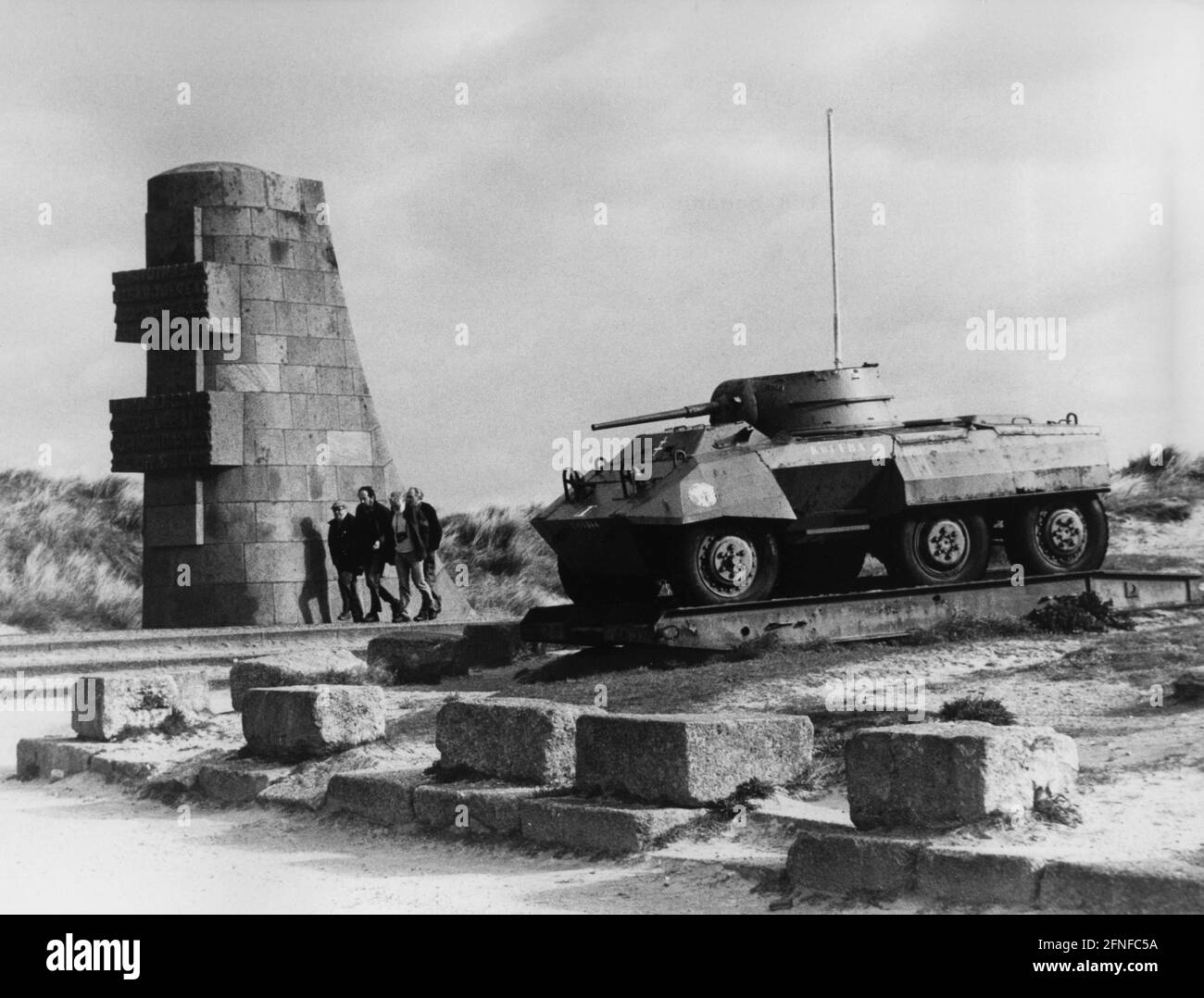 "La colonna commemorativa del D-Day Port-en-Bassin, accanto ad essa un veicolo da ricognizione blindato americano del tipo M8 ''Greyhound'', che apparteneva alla divisione francese blindée. [traduzione automatizzata]" Foto Stock