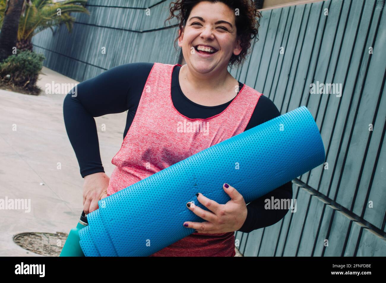 Donna in sovrappeso che ride mentre fa sport. Formazione di obesità in positività. Accettazione del corpo Foto Stock