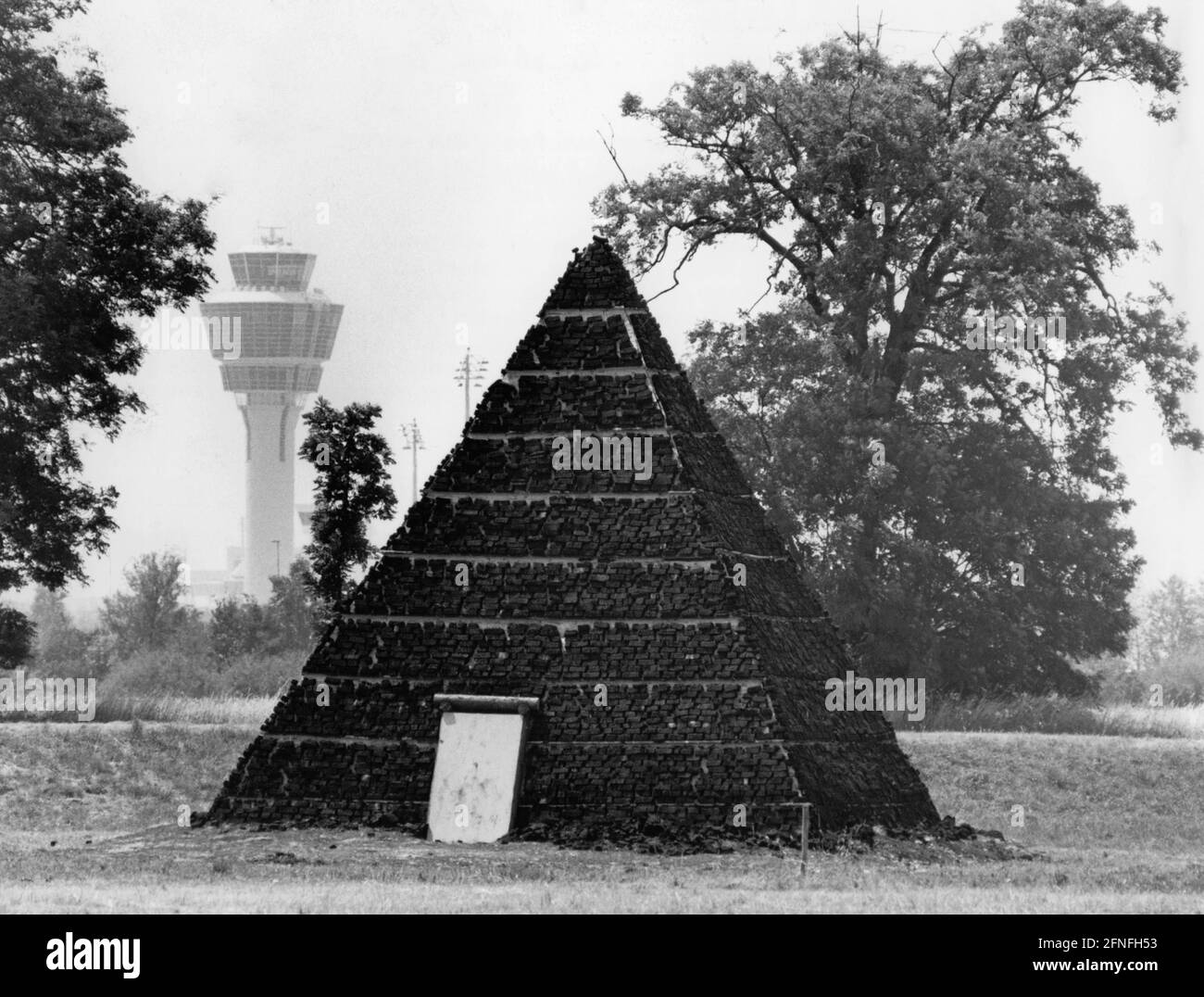 La ''Piramide bavarese'' di Rudolf L. Reiter, fatta di mattoni di torba, decora i dintorni del nuovo aeroporto nei giardini di Erdinger. La torre dell'aeroporto può essere vista sullo sfondo. [traduzione automatizzata]" Foto Stock