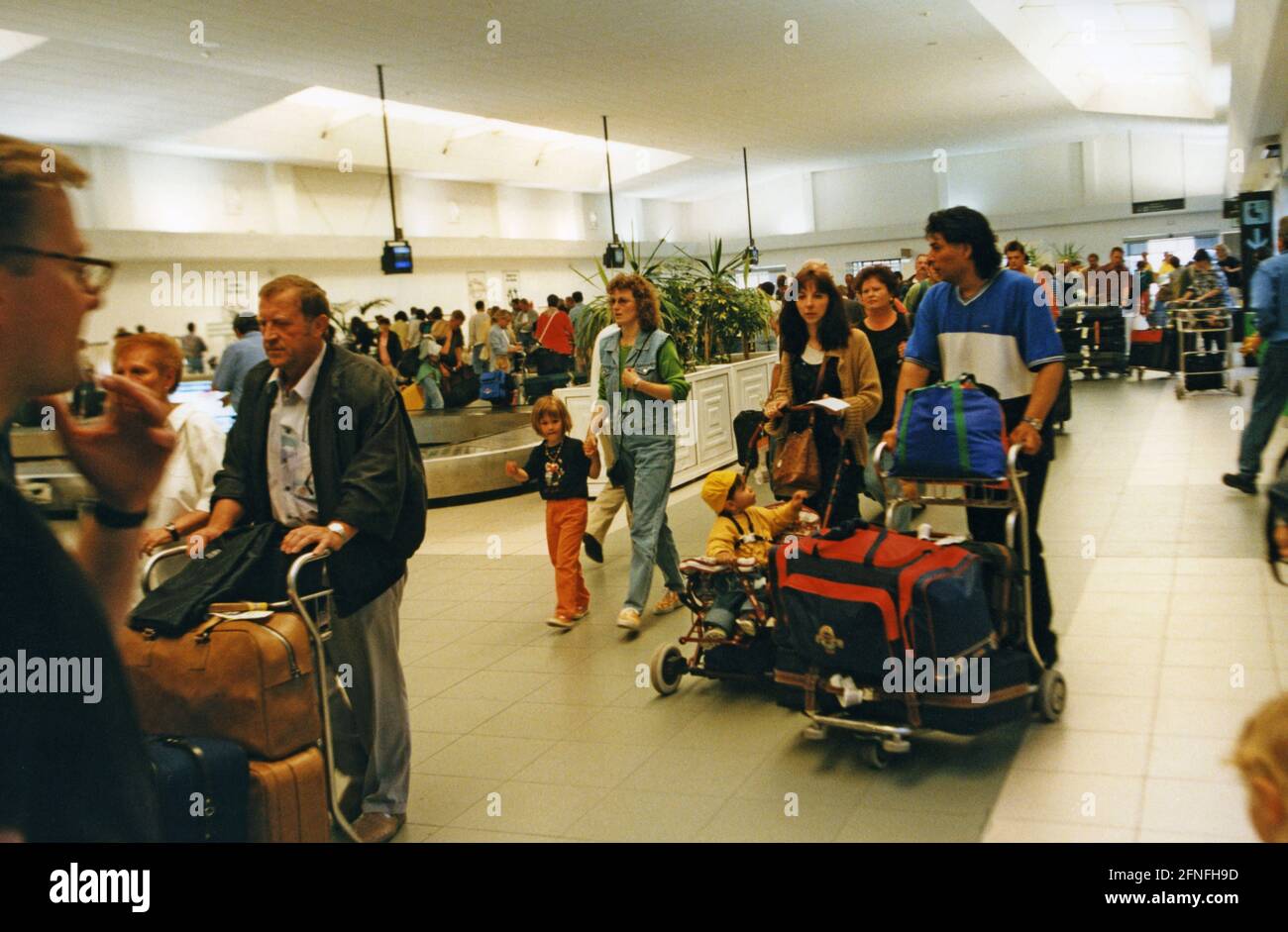 Viaggiatori nella sala bagagli dell'aeroporto di Lanzarote. Dopo l'atterraggio, i turisti aspettano i trasportatori bagagli. [traduzione automatizzata] Foto Stock