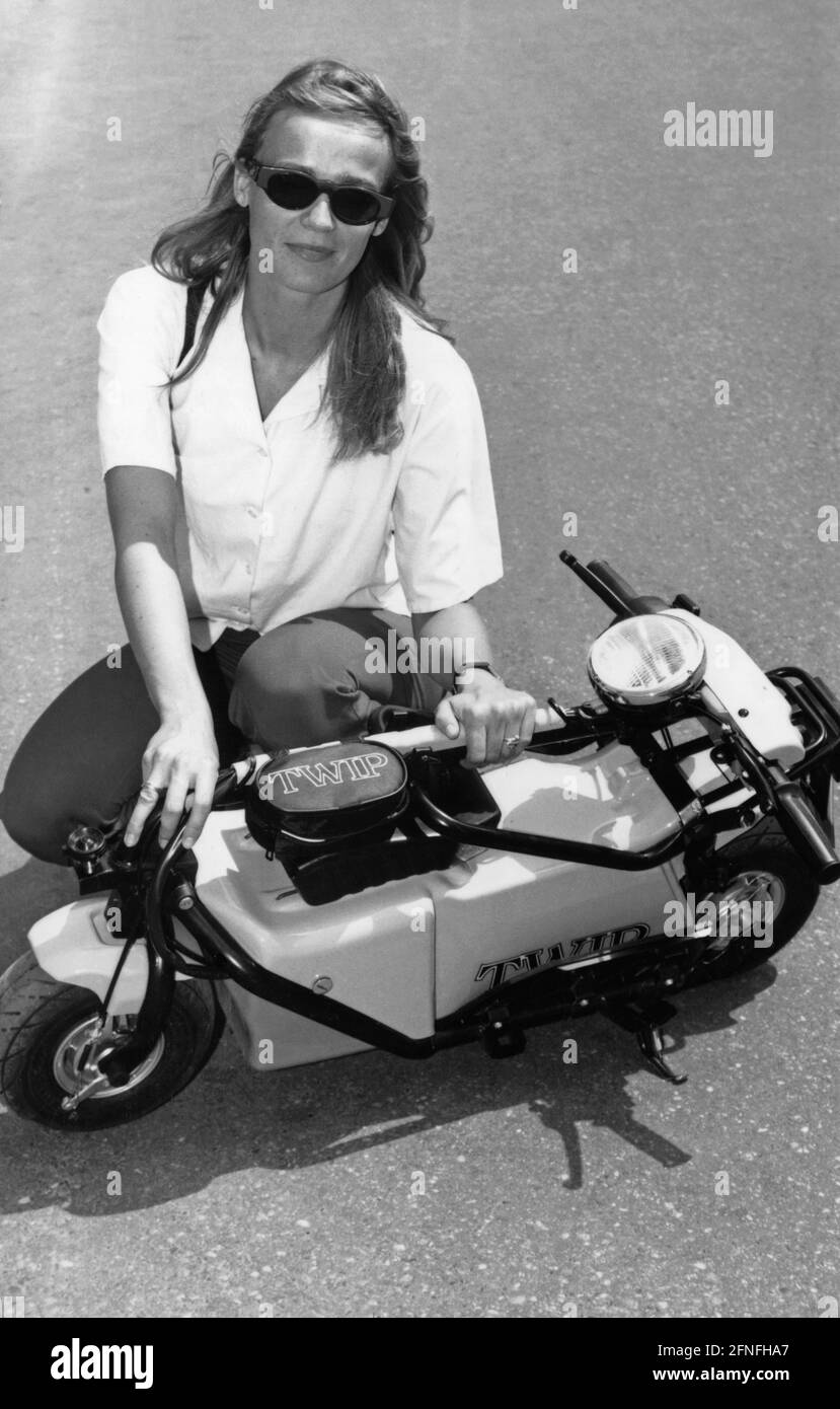 Una donna si inginocchia accanto a uno scooter elettrico TWIP ripiegato. Il TWIP è stato il primo scooter elettrico ad essere approvato per il traffico stradale tedesco. [traduzione automatizzata] Foto Stock