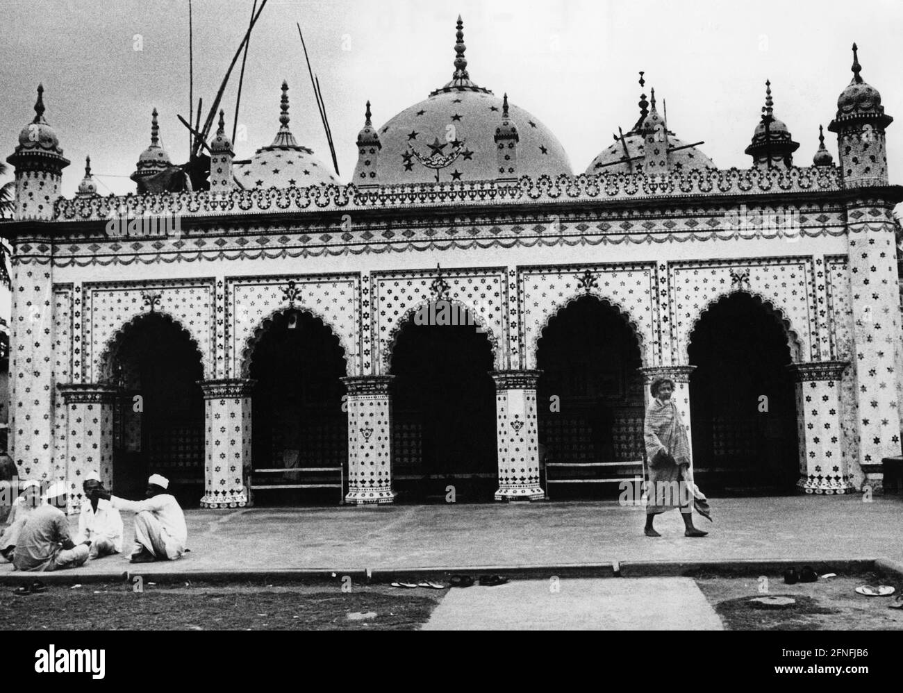 Vista esterna della Moschea delle Stelle a Dhaka, Bangladesh. Di fronte alla moschea alcuni uomini sono seduti insieme, un uomo sta lasciando la moschea. Fotografia non datata. [traduzione automatizzata] Foto Stock