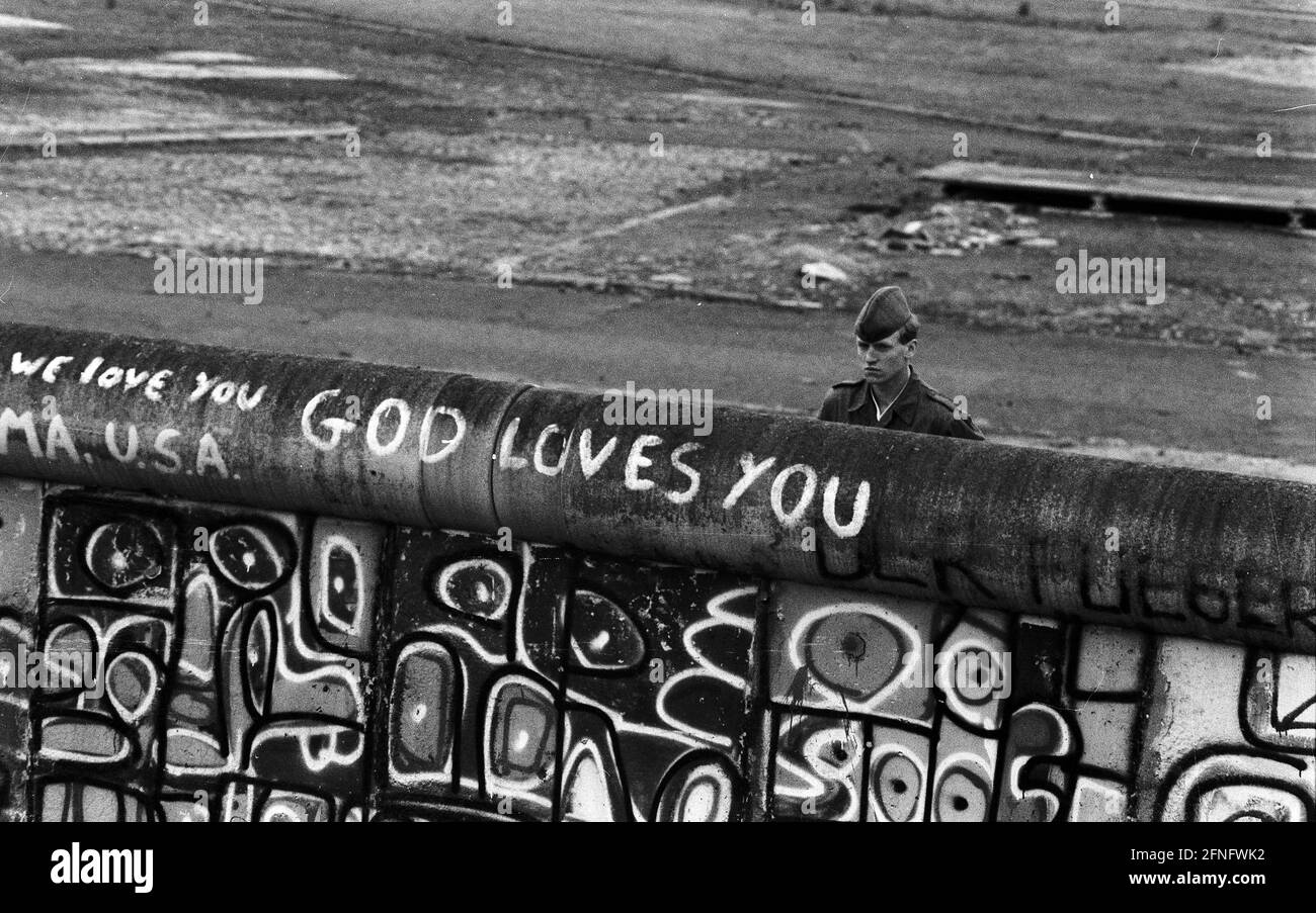 Berlino-Città / Mitte / GDR / 6 / 1988 Potsdamer Platz: Le guardie di frontiera della RDT guardano a Berlino Ovest. I giovani hanno occupato un pezzo di terra di nessuno lì. È in Occidente ma appartiene all'Oriente. La polizia di Berlino Ovest sta per schiarirla. La guardia di confine della GDR non sa cosa è scritto sul lato ovest del muro: -Dio ti ama- // parete della GDR / Storia / comunismo / Stato della GDR [traduzione automatizzata] Foto Stock