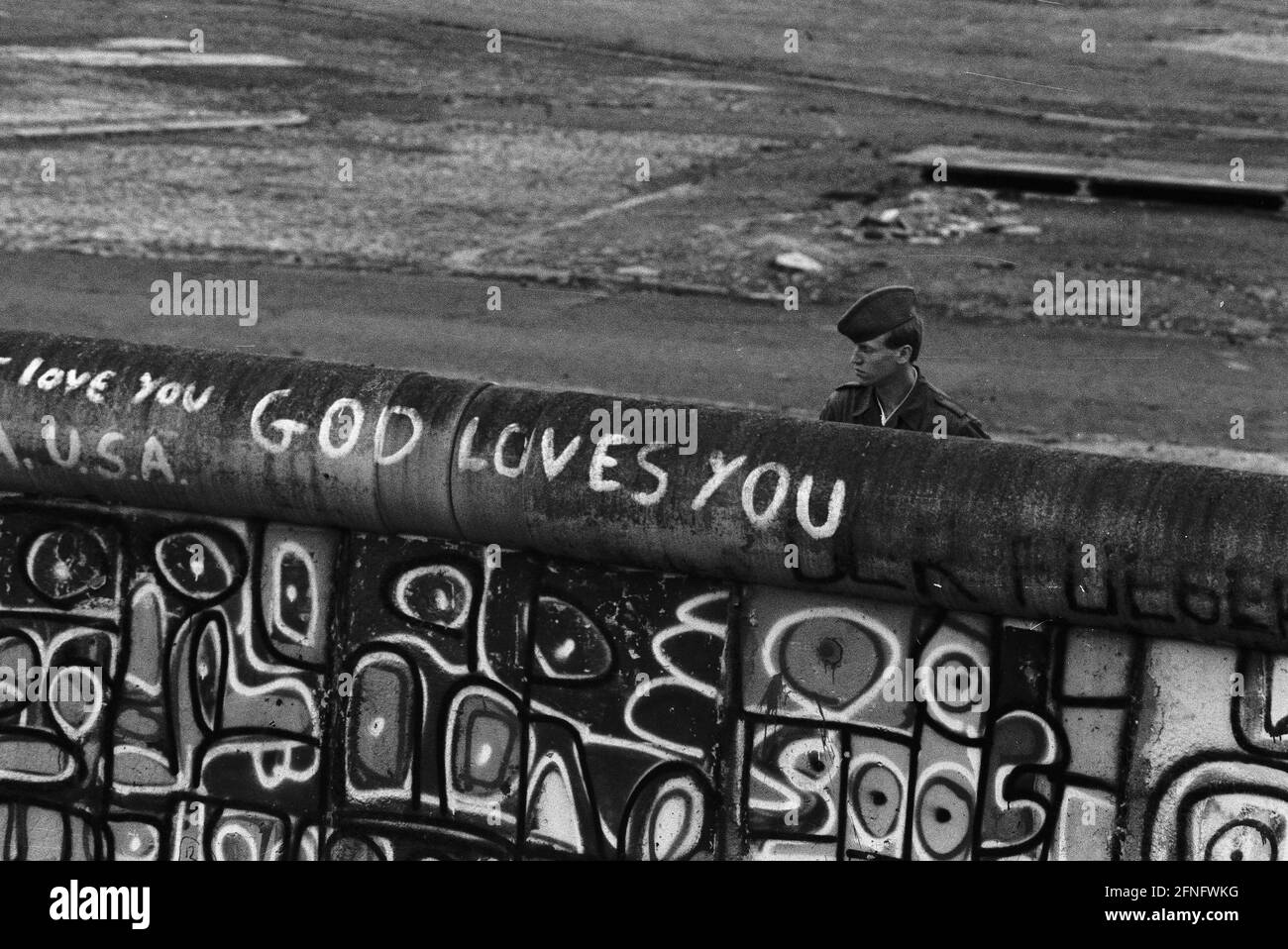 Berlino-Città / Mitte / GDR / 6 / 1988 Potsdamer Platz: Le guardie di frontiera della RDT guardano a Berlino Ovest. I giovani hanno occupato un pezzo di terra di nessuno lì. È in Occidente ma appartiene all'Oriente. La polizia di Berlino Ovest sta per schiarirla. La guardia di confine della GDR non sa cosa è scritto sul lato ovest del muro: -Dio ti ama- // parete della GDR / Storia / comunismo / Stato della GDR [traduzione automatizzata] Foto Stock