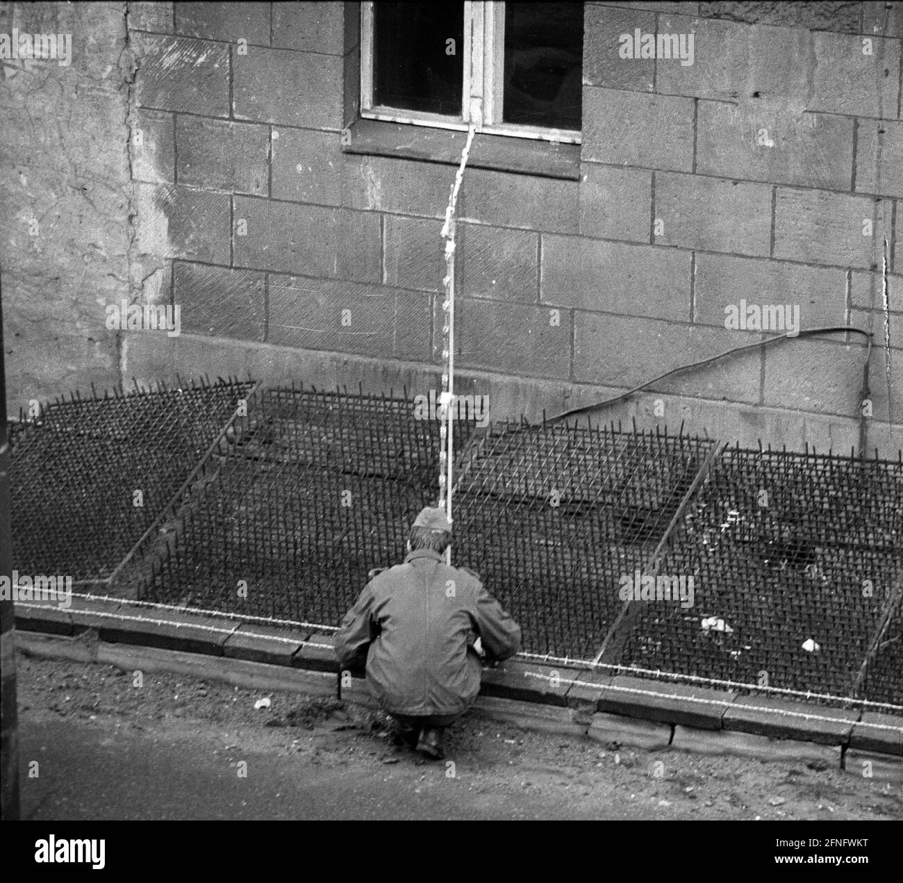 Berlino / Neukoelln / parete della DDR / 10 / 1980 parete della DDR a Bouchestrasse tra Neukoelln e Treptow. Il confine sale fino alle case di Berlino Est. Per questo motivo, le guardie di frontiera della RDT posano dei tappetini con zerbini sotto le finestre per impedire ai residenti di fuggire in Occidente. // Installazione frontaliera/ Stasi [traduzione automatizzata] Foto Stock