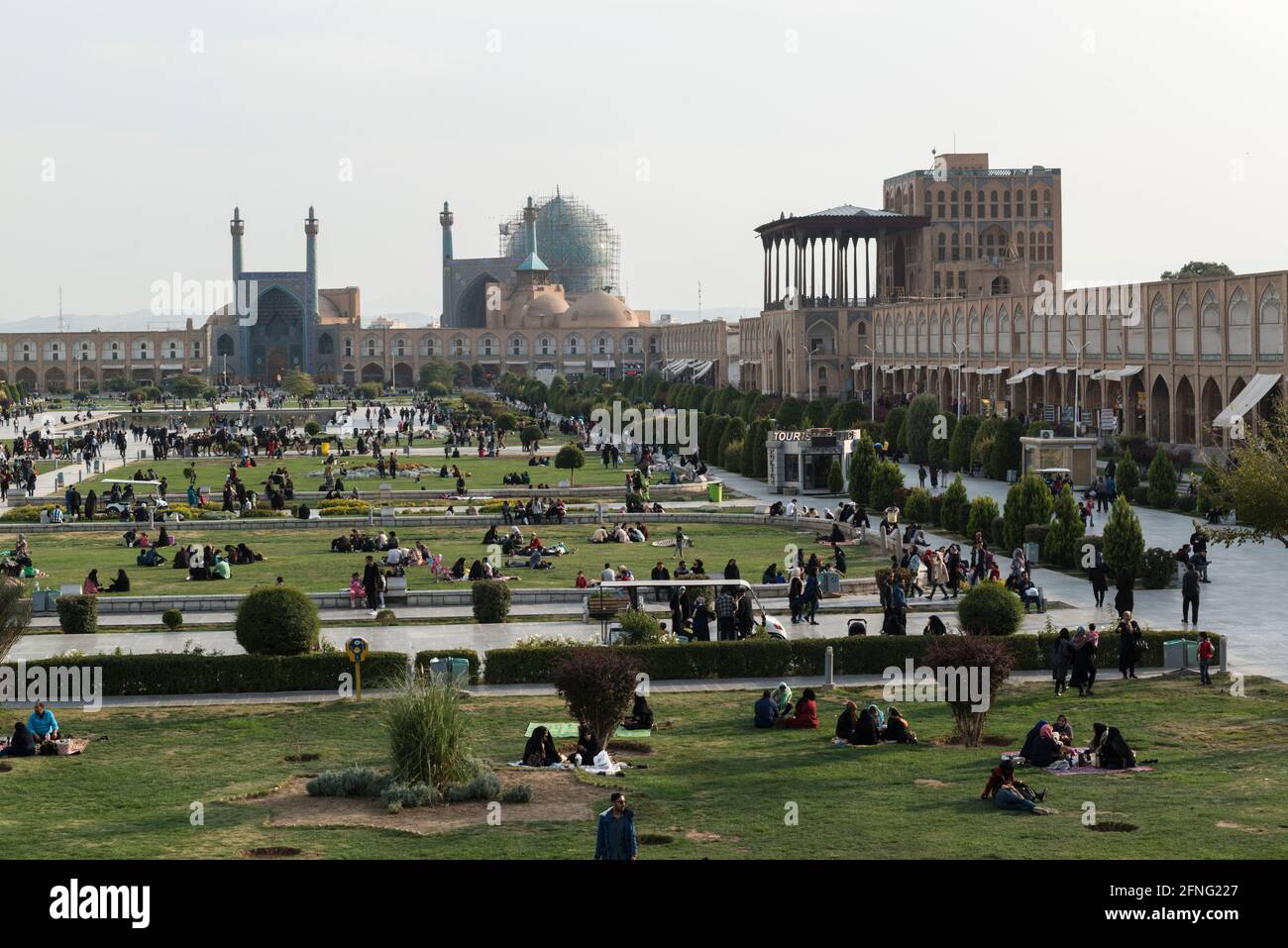Piazza Naqsh-e Jahān affollata di persone con picnic, la Moschea Shah (al centro) e Ali Qapu (a destra) Foto Stock