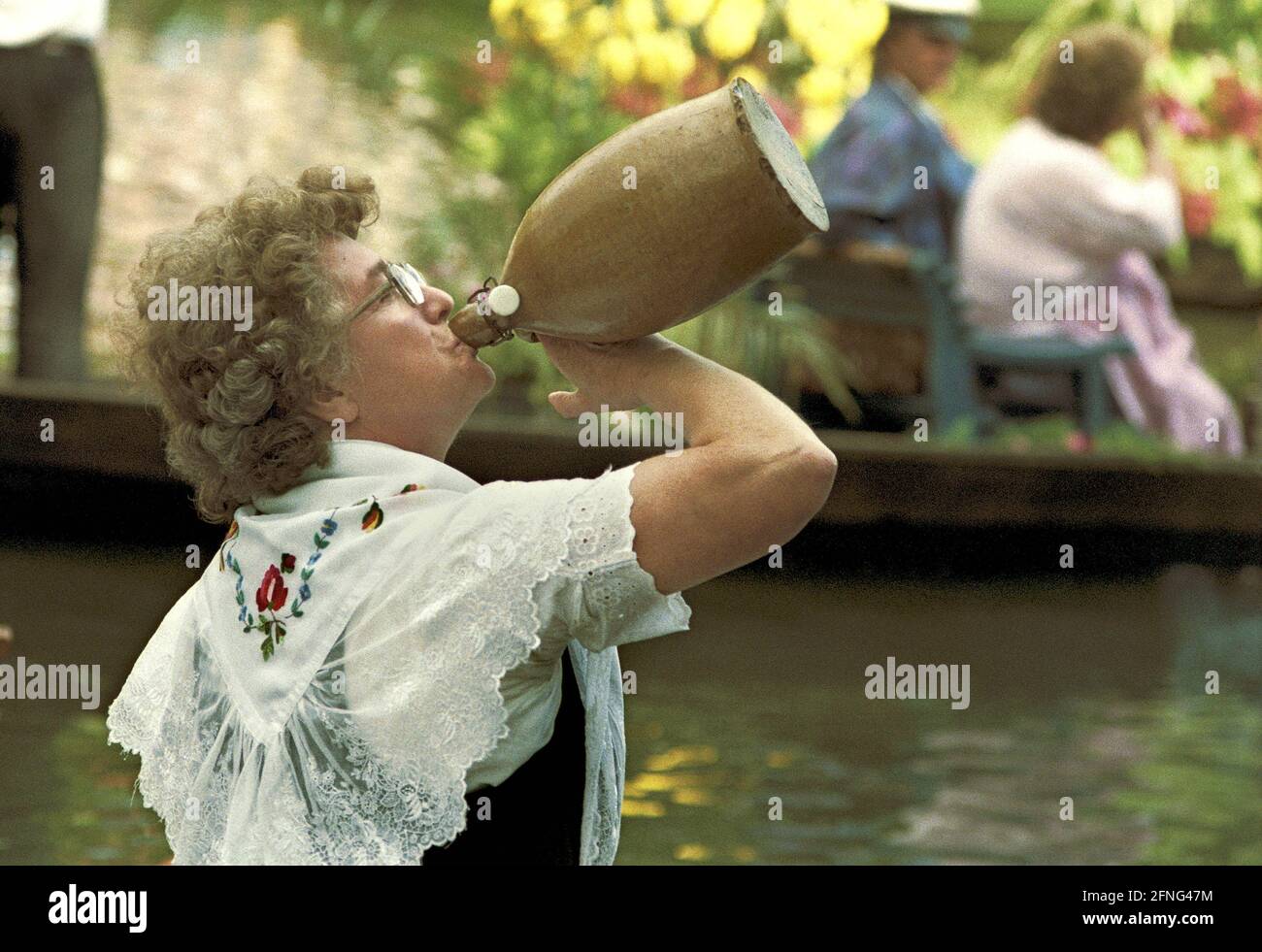 Brandeburgo / DDR / 6 / 1990 Luebben nel Spreewald, parata annuale di chiatte. Una donna di chiatta prende un sorso prima della sfilata // Festivals / lavoro / Donne / Folklore / Turismo / persone / [traduzione automatizzata] Foto Stock
