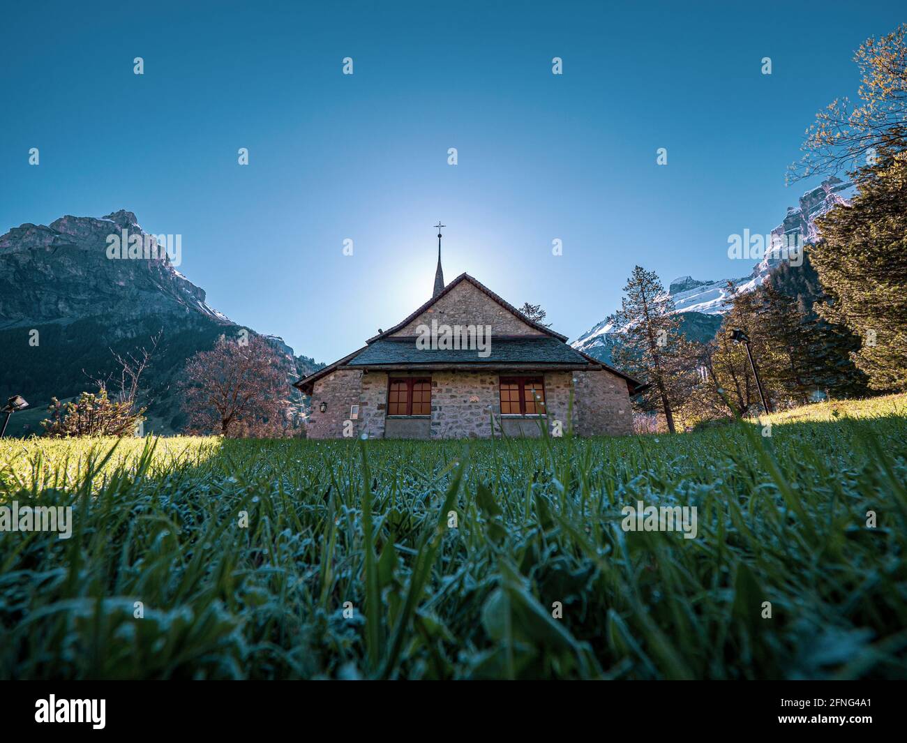 Bella vecchia chiesa rustica alpina e montagne innevate. La chiesa si trova nel villaggio alpino di kandersteg in Svizzera. Foto Stock