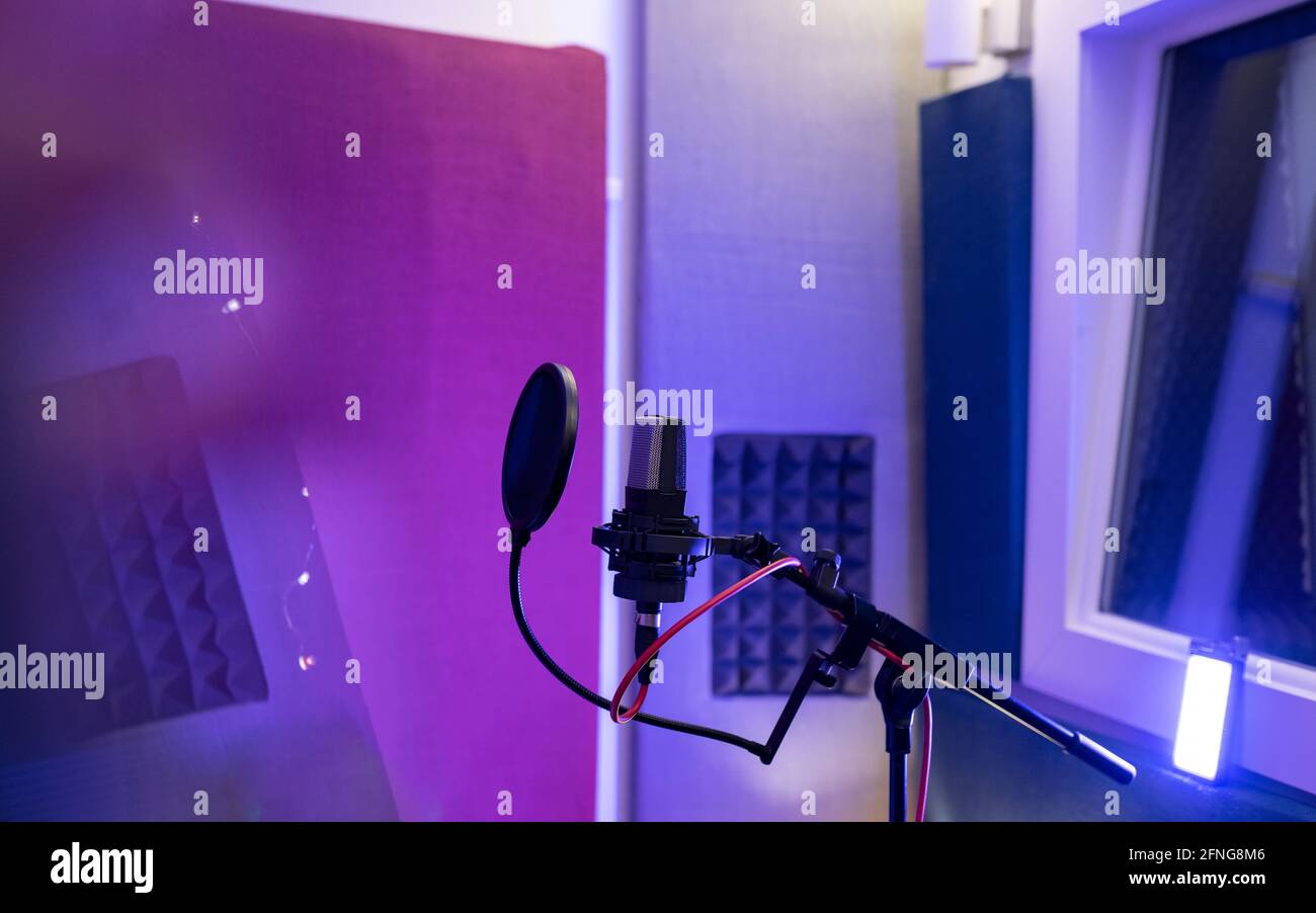 Filtro pop e microfono dinamico moderno con fili vuoti studio audio su sfondo sfocato Foto Stock